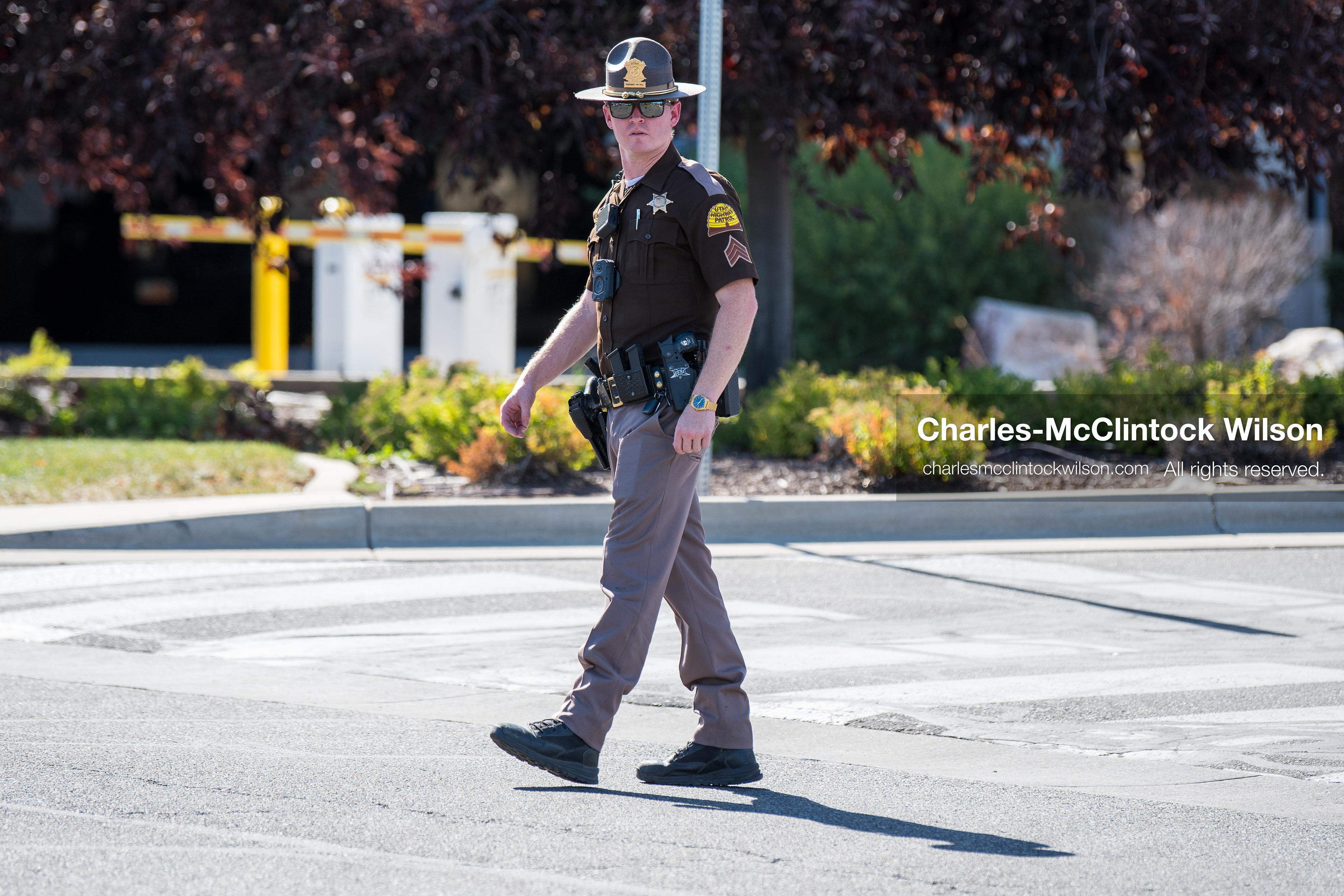 A Utah Highway Patrol trooper patrols a crosswalk checkpoint outside Intermountain Medical Center in Murray, Utah, United States, on August 17, 2026. Multiple regional police agencies secured the hospital perimeter as a safety precaution after shooting victims were admitted following a fatal shootout outside a funeral service in nearby Kearns. (Photo by Charles-McClintock Wilson/NurPhoto)