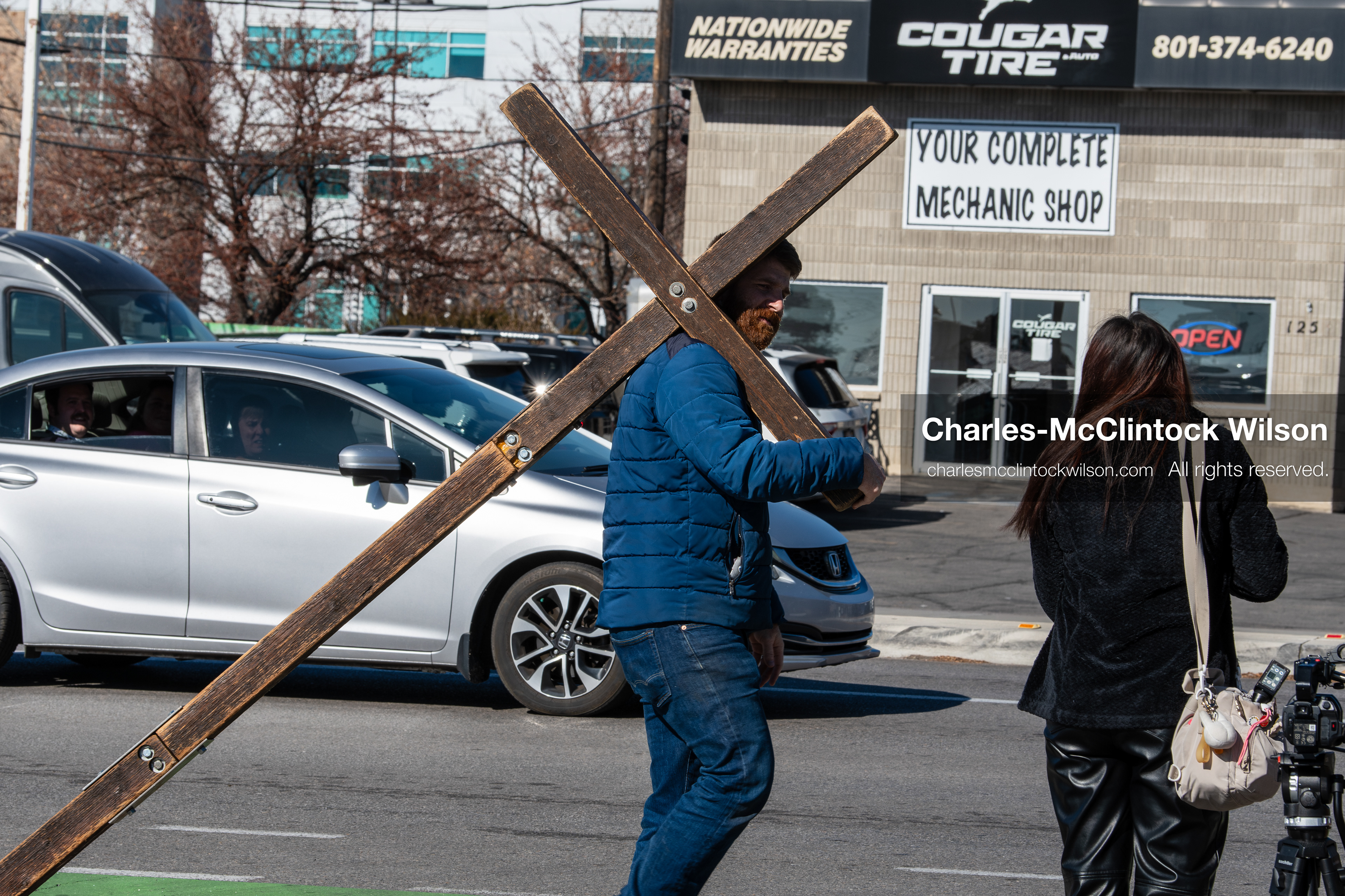 February 5, 2026, Provo, Utah, USA: A man carries a wooden cross while walking near Brigham Young University in Provo during a protest opposing the presence of US Customs and Border Protection recruiters at a career fair held on the BYU campus. (Credit Image: © Charles McClintock Wilson/ZUMA Press Wire)