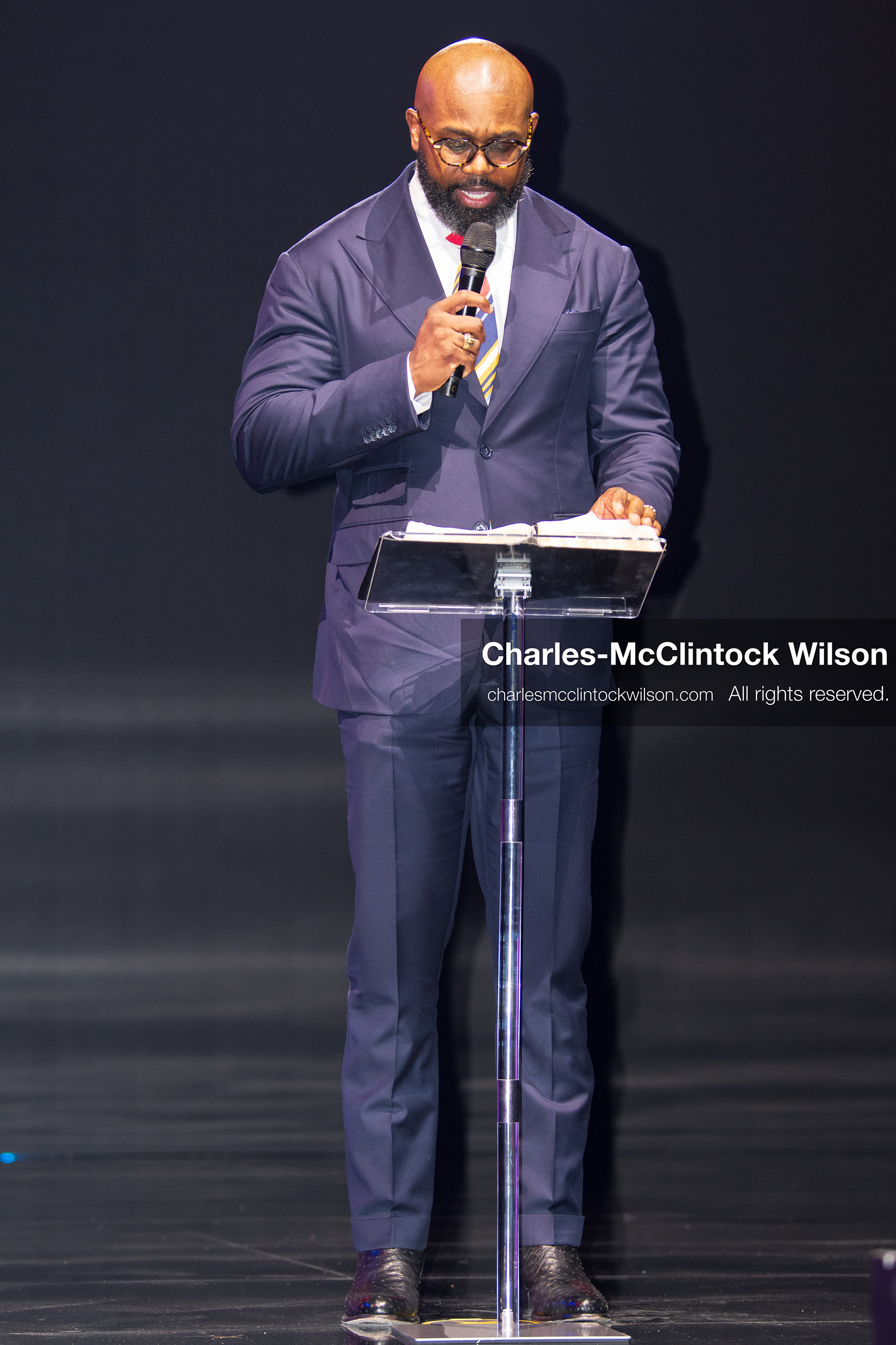 December 18, 2025, Phoenix, Arizona, USA: Pastor John Amanchukwu speaks on stage during AmericaFest 2025 at the Phoenix Convention Center, holding a microphone behind a transparent podium. (Credit Image: (c) Charles-McClintock Wilson/ZUMA Press Wire)