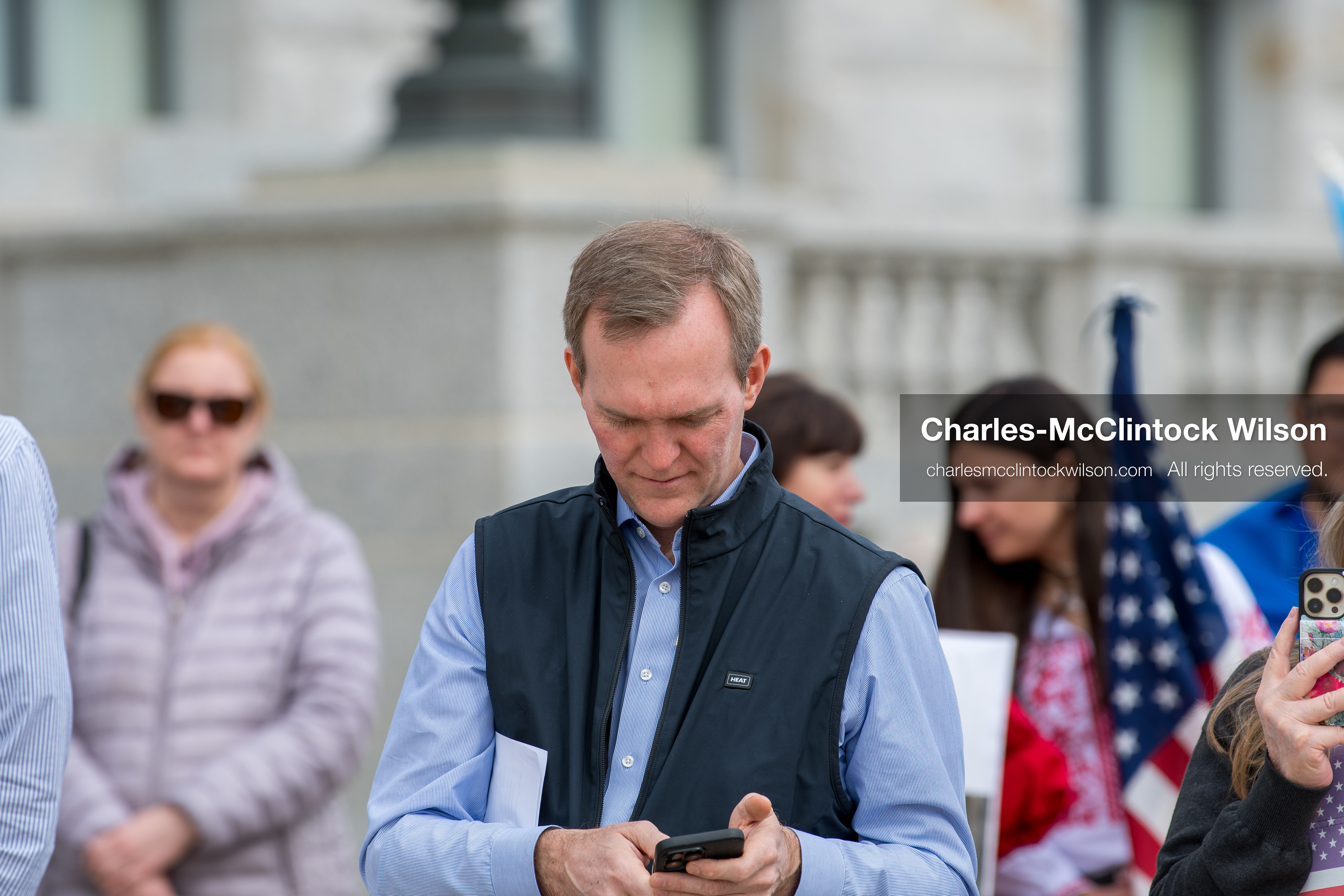 February 28, 2026, Salt Lake City, Utah, USA: BEN MCADAMS, former U.S. Congressman and a Democrat from Utah, checks his phone as attendees gather during the Stand With Ukraine rally at the Utah State Capitol. The event marked the four year anniversary of the full scale Russian invasion of Ukraine and brought community members together in support of Ukrainians and local humanitarian efforts. (Credit Image: © Charles McClintock Wilson/ZUMA Press Wire)
