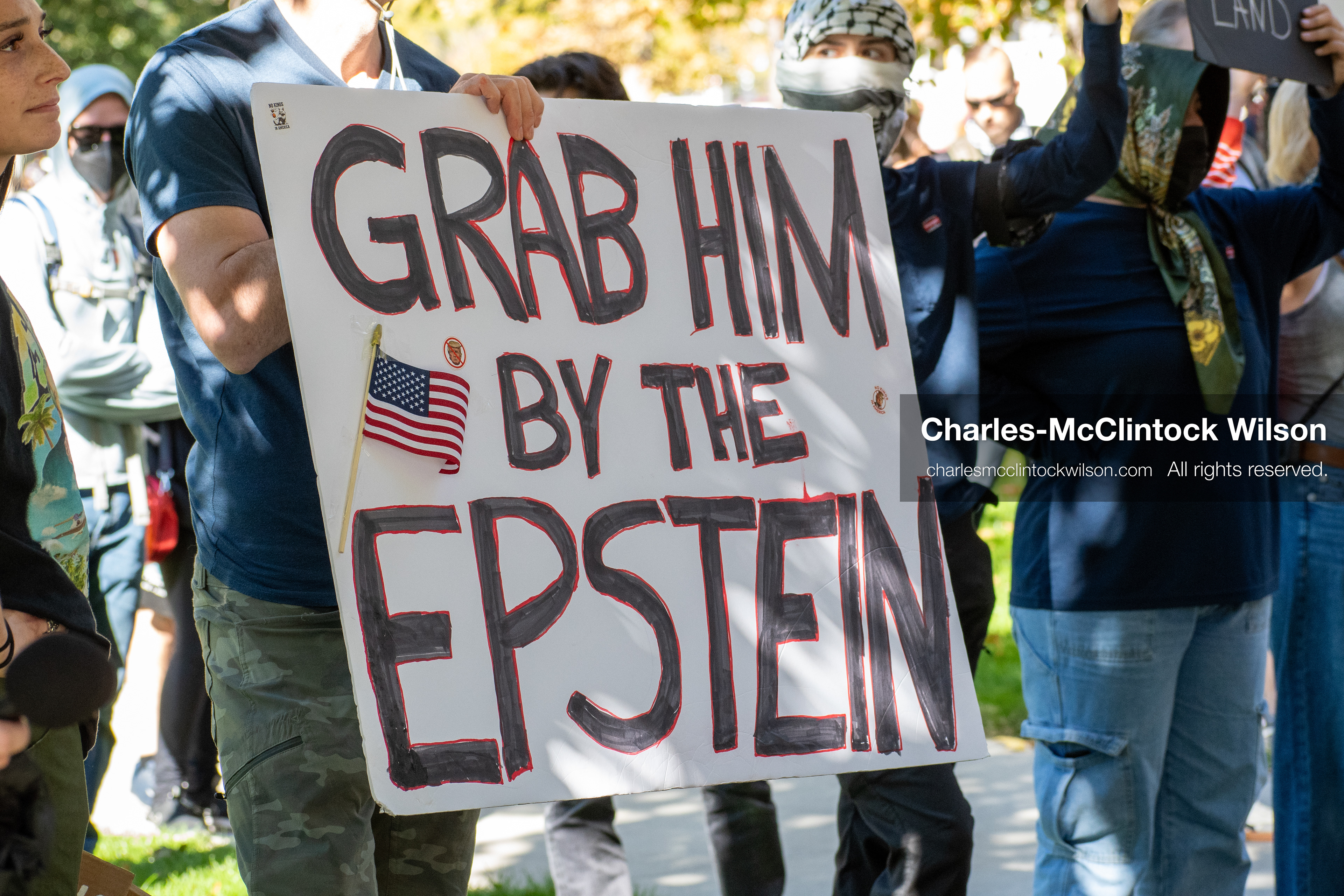 October 18, 2025, Salt Lake City, Utah, USA: A demonstrator holds a protest sign during a "No Kings" rally at Washington Square Park in Salt Lake City, Utah. The protest was part of a nationwide mobilization.