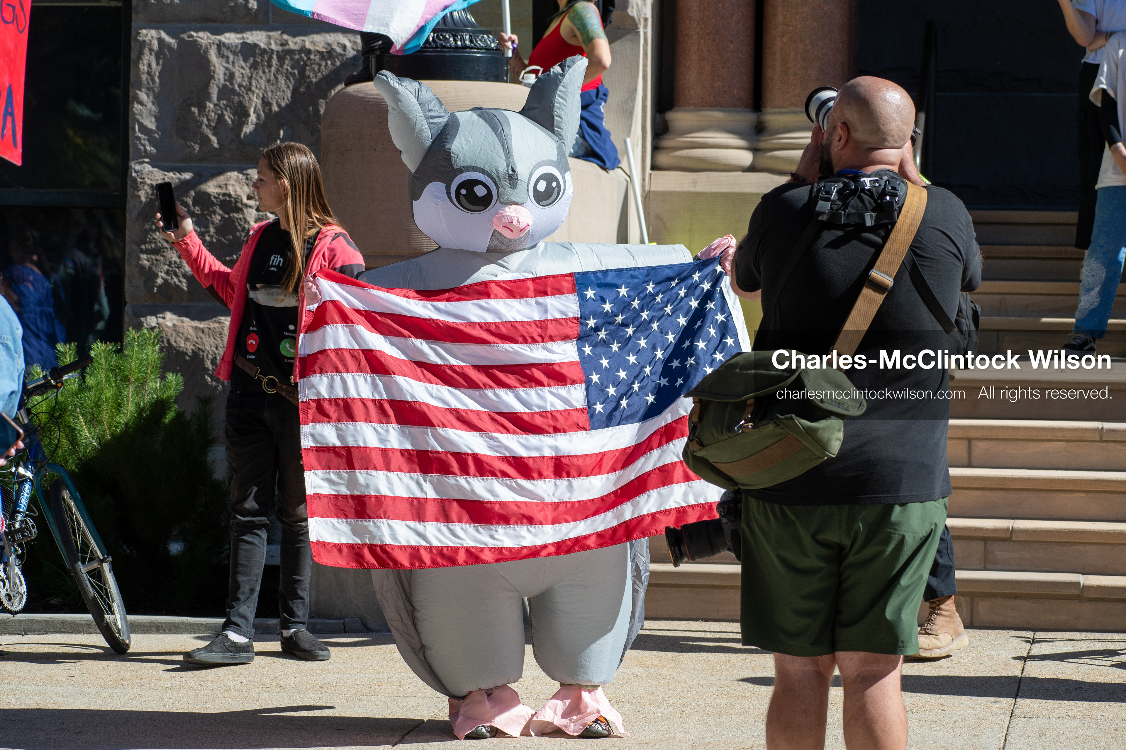 October 18, 2025, Salt Lake City, Utah, USA: A demonstrator in costume holds an American flag during a "No Kings" rally at Washington Square Park in Salt Lake City, Utah. The protest was part of a nationwide mobilization.