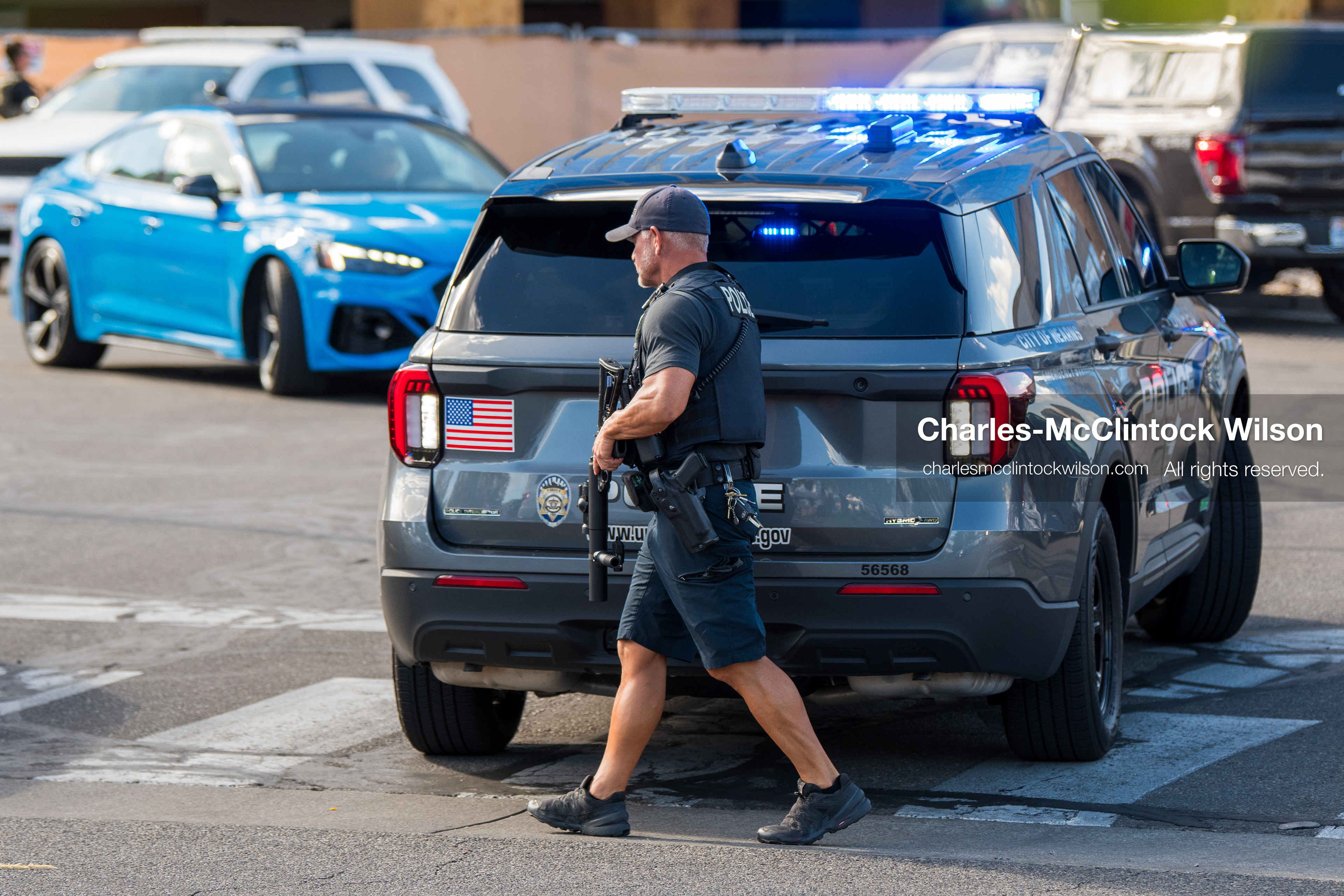 An armed law enforcement officer patrols a sidewalk perimeter outside Intermountain Medical Center in Murray, Utah, United States, on August 17, 2026. Multiple regional police agencies secured the hospital perimeter as a safety precaution after shooting victims were admitted following a fatal shootout outside a funeral service in nearby Kearns. (Photo by Charles-McClintock Wilson/NurPhoto)