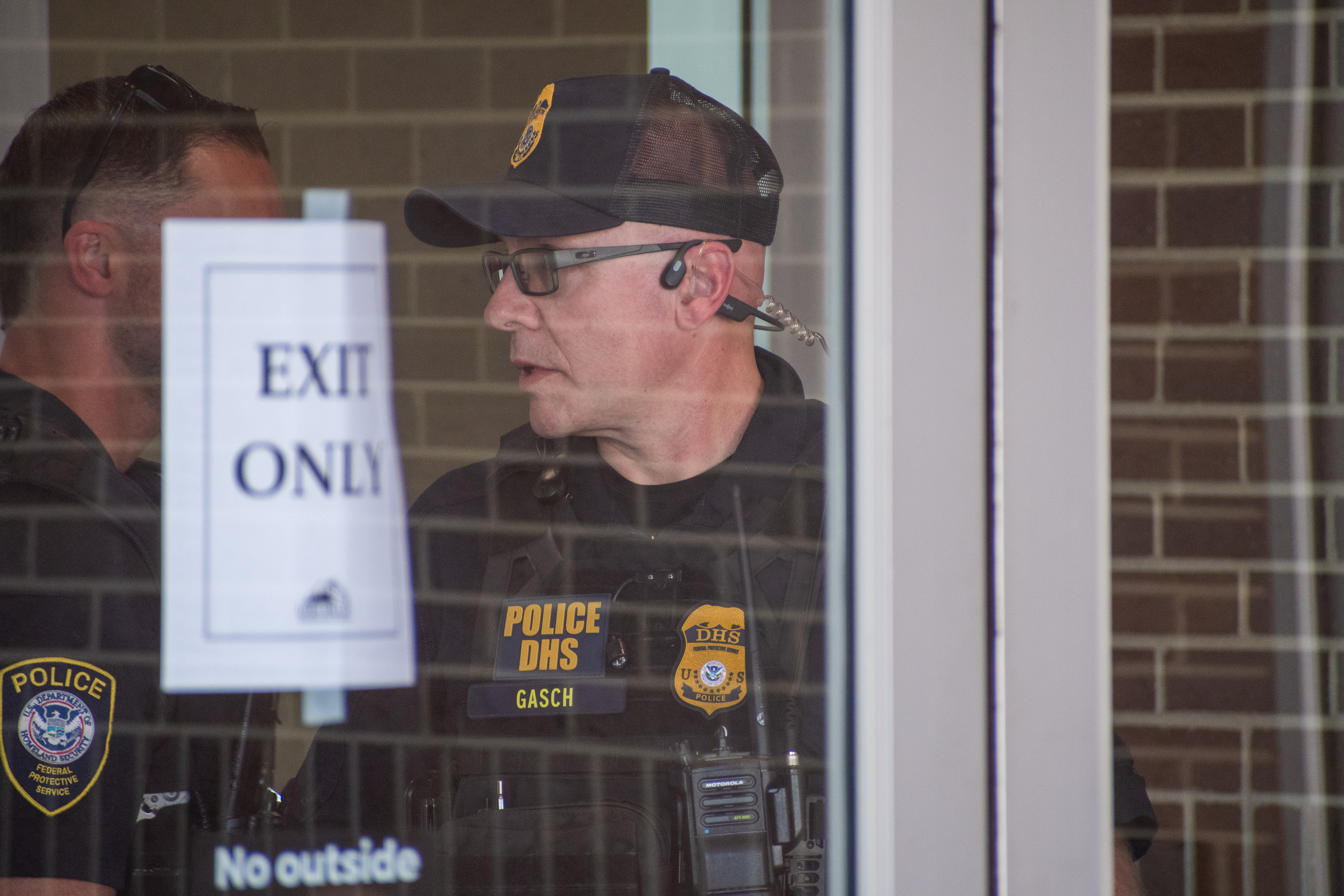 September 15, 2025 – Provo, Utah, United States: Two Homeland Security police officers are seen behind a glass door marked “EXIT ONLY” at the Utah Valley Convention Center during a Department of Homeland Security career expo focused on recruiting law enforcement and security personnel. Photograph by Charles‑McClintock Wilson / ZUMA Press Wire