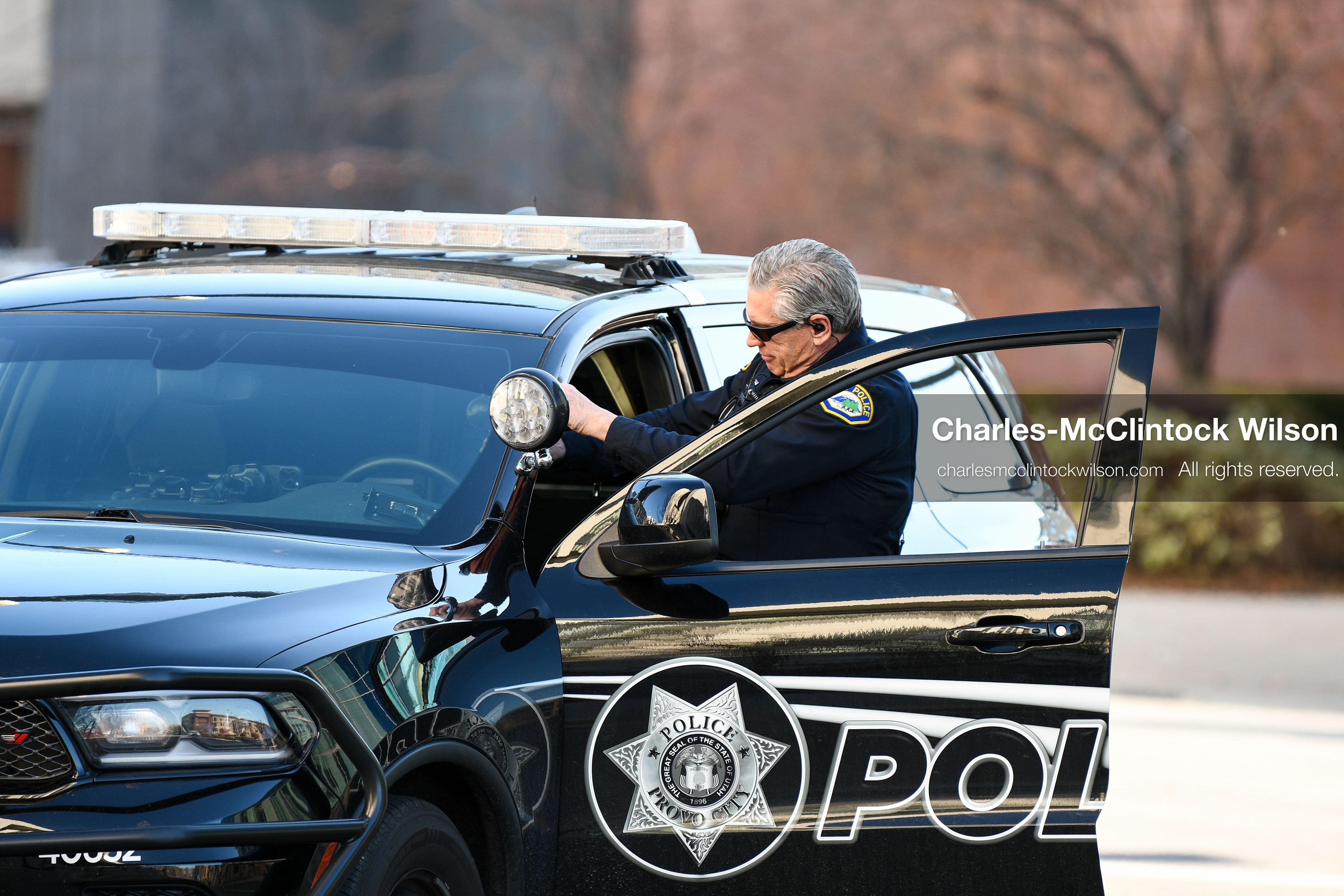 PROVO, UTAH, USA – DECEMBER 11, 2025: A Provo Police officer gets into a patrol vehicle near the Fourth District Court in Provo during the first in‑person court appearance of Tyler Robinson in the Charlie Kirk murder case. (Credit Image: © Charles‑McClintock Wilson/ZUMA Press Wire)