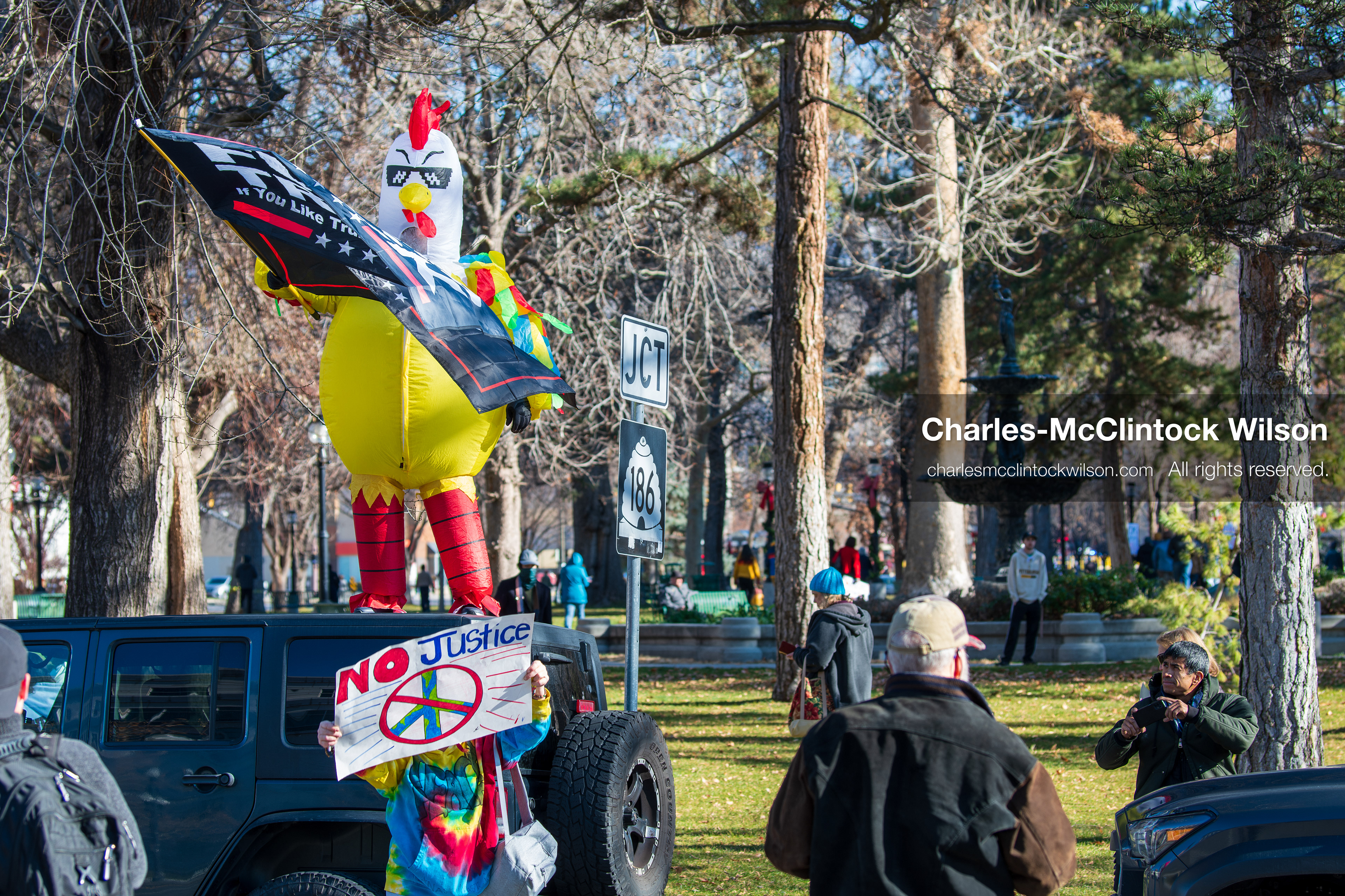 Salt Lake City, Utah, January 10, 2026: A person wearing a chicken costume stands on top of a vehicle during the ICE Out for Good protest at Washington Square Park, holding two flags with anti‑ICE and anti‑Trump messaging. (Credit Image: © Charles‑McClintock Wilson/ZUMA Press Wire)
