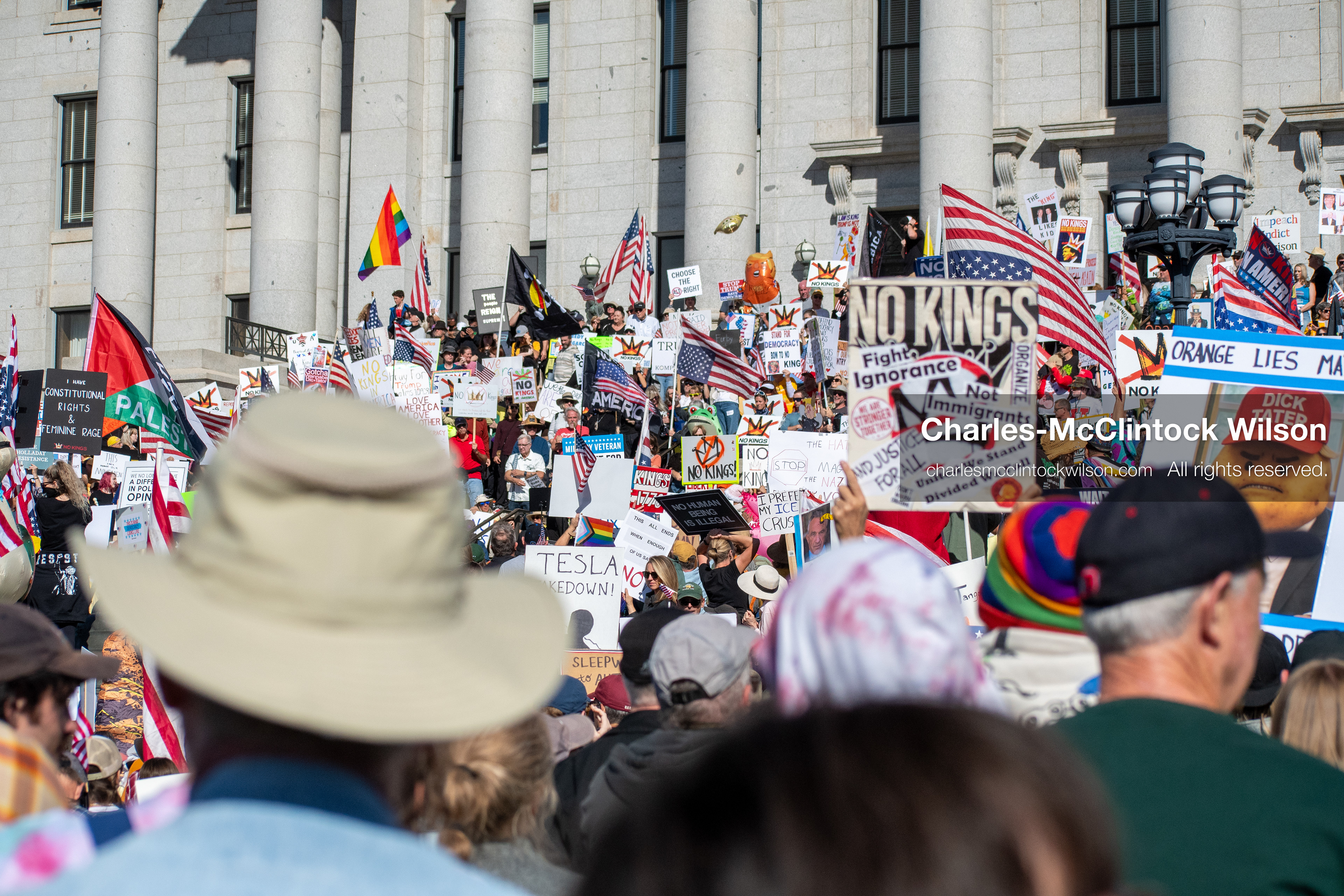 October 18, 2025, Salt Lake City, Utah, USA: Demonstrators gather on the steps of the Utah State Capitol during a "No Kings" protest held as part of a nationwide mobilization. Participants hold signs and flags while documenting the event. The protest was one of several organized across the United States.