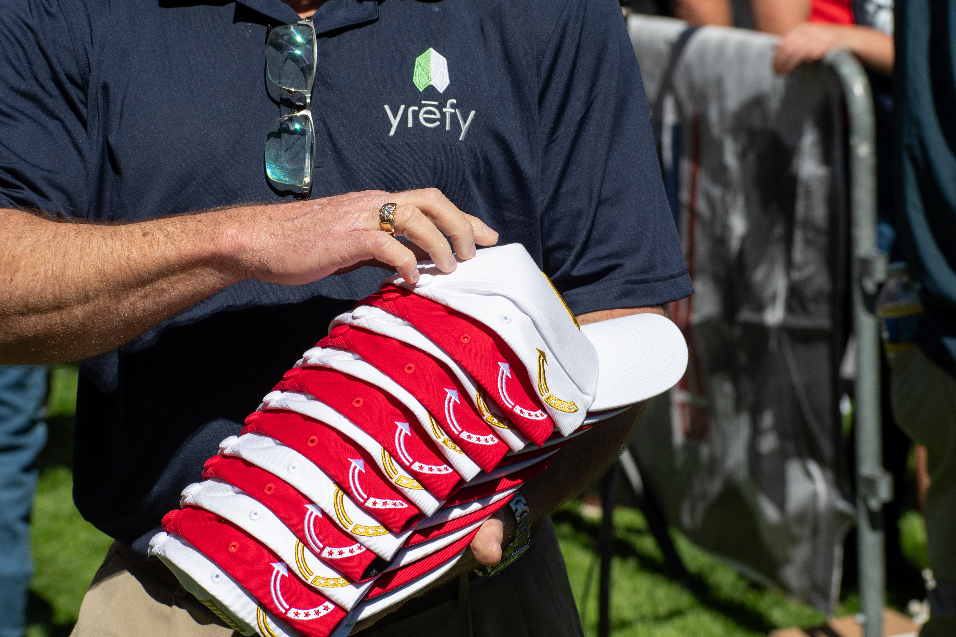OREM, UTAH – SEPTEMBER 10, 2025: An event staffer organizes merchandise ahead of Charlie Kirk’s scheduled appearance at Utah Valley University. Holding a stack of red and white caps, the individual reflects the logistical coordination and quiet preparation that shaped the opening stop of the American Comeback Tour. The image captures a moment of order, presence, and behind-the-scenes engagement. © Charles-McClintock Wilson / ZUMA Press
