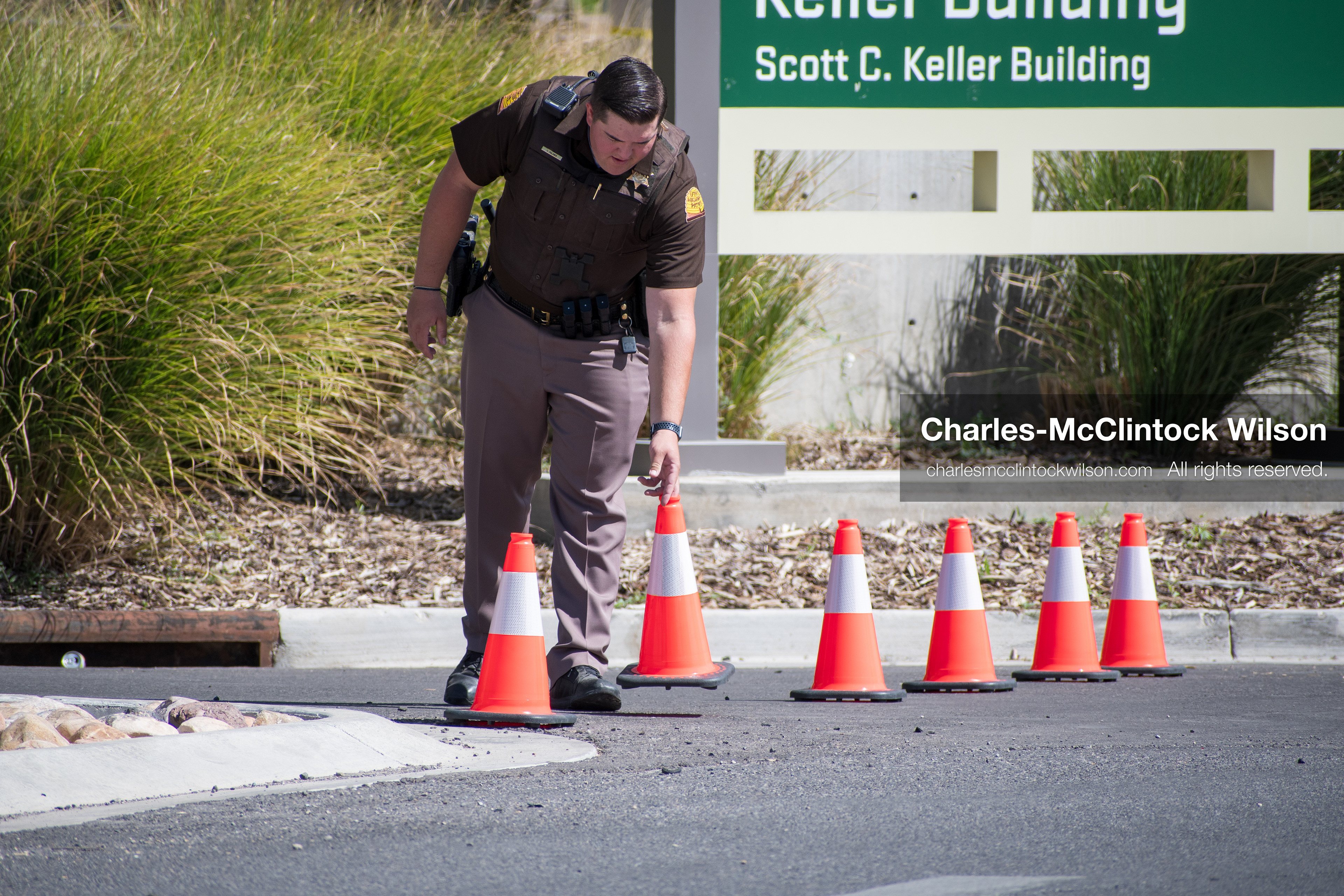 September 12, 2025, Orem, Utah, USA: A Utah Highway Patrol officer inspects the ground near a row of traffic cones outside the Keller Building at Utah Valley University, near the site of the fatal shooting of conservative activist Charlie Kirk. The area remains cordoned off as the investigation continues following the September 10 incident.   (Credit Image: © Charles‑McClintock Wilson/ZUMA Press Wire)