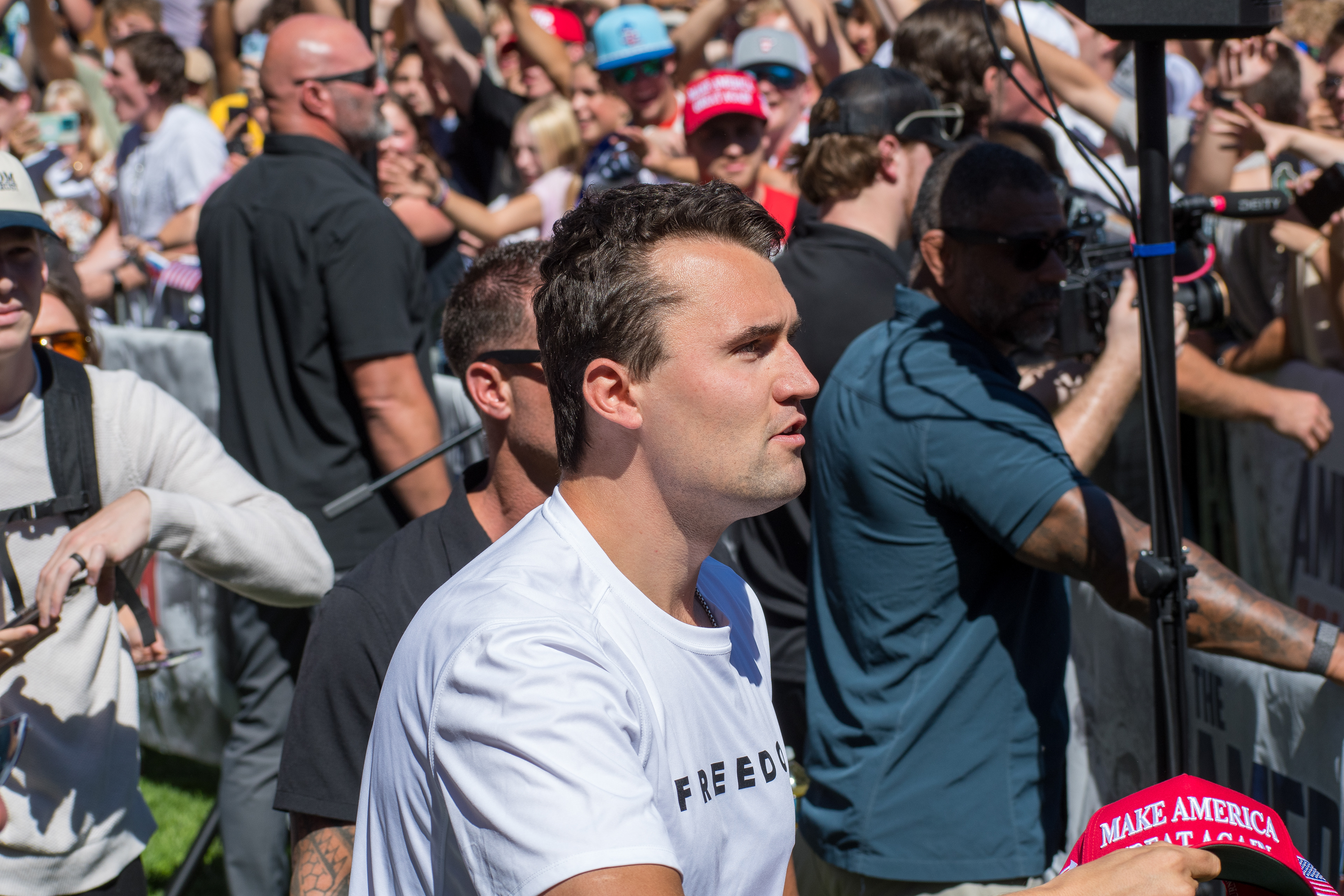 OREM, UTAH – SEPTEMBER 10, 2025: Charlie Kirk holds several “Make America Great Again” hats while interacting with supporters during a public event at Utah Valley University. Positioned near a merchandise table and surrounded by attendees, Kirk engages directly with the crowd in one of his final public moments. The image reflects the branding, outreach, and political symbolism that defined the gathering. © Charles-McClintock Wilson / ZUMA Press 