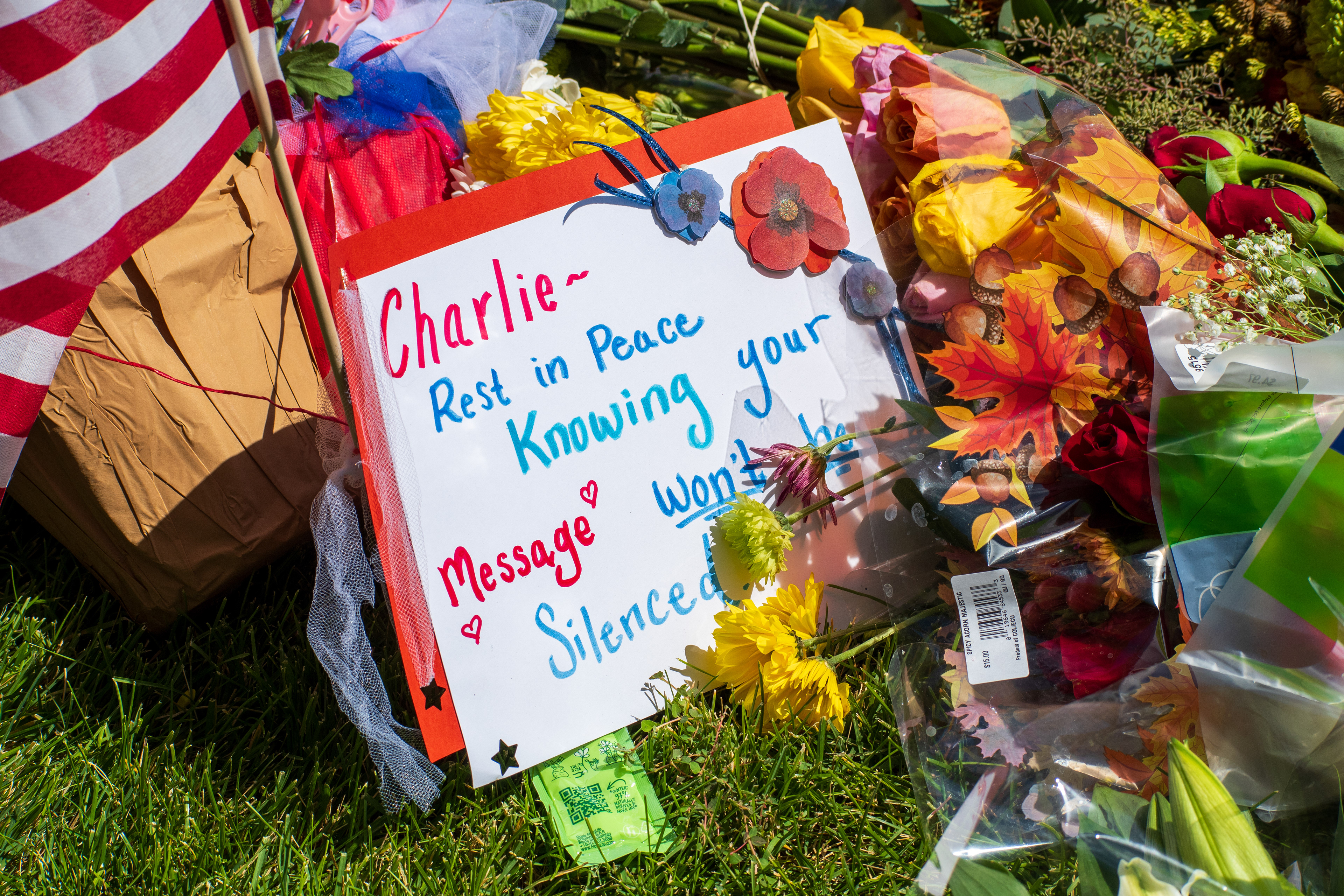 OREM, UTAH – SEPTEMBER 12, 2025: A handwritten sign reading “Rest in Peace Knowing Your Message Won’t Be Silenced” is placed among flowers and an American flag at a memorial site for Charlie Kirk near Utah Valley University. The tribute reflects a personal and patriotic gesture of remembrance. © Charles‑McClintock Wilson / ZUMA Press