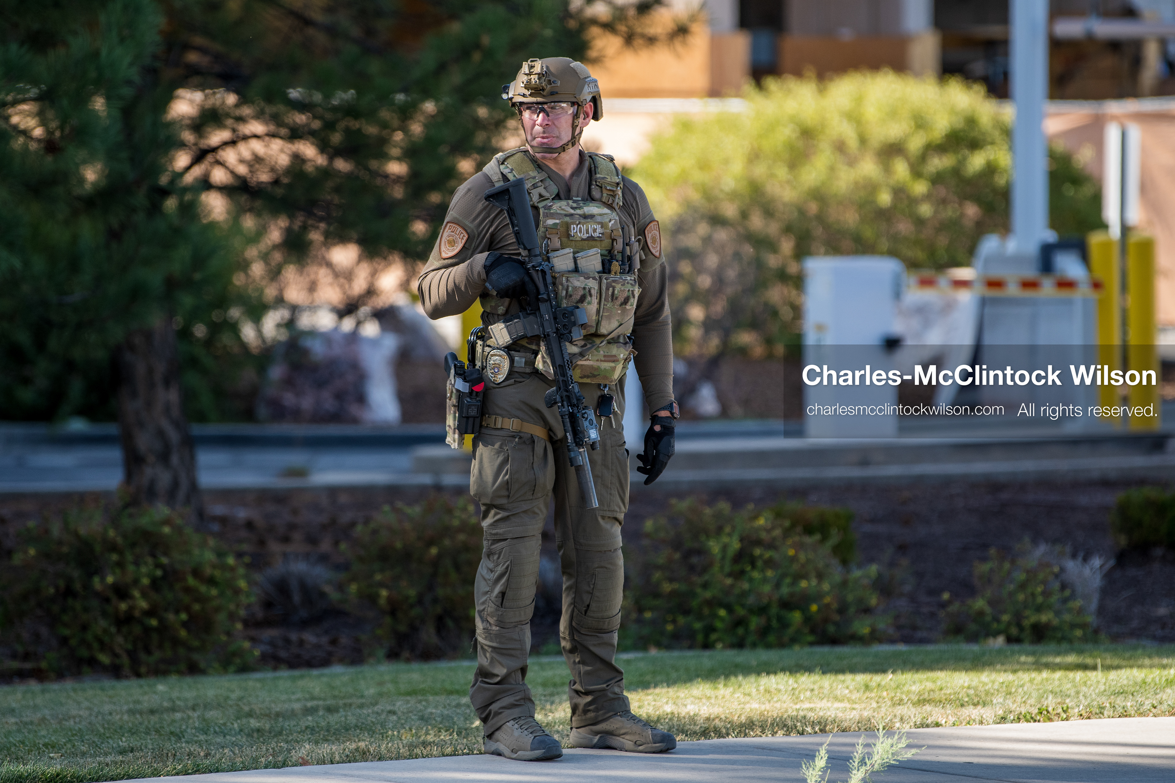 An armed law enforcement officer wearing a helmet and tactical gear stands guard outside Intermountain Medical Center in Murray, Utah, United States, on August 17, 2026. Multiple regional police agencies secured the hospital perimeter as a safety precaution after shooting victims were admitted following a fatal shootout outside a funeral service in nearby Kearns. (Photo by Charles-McClintock Wilson/NurPhoto)