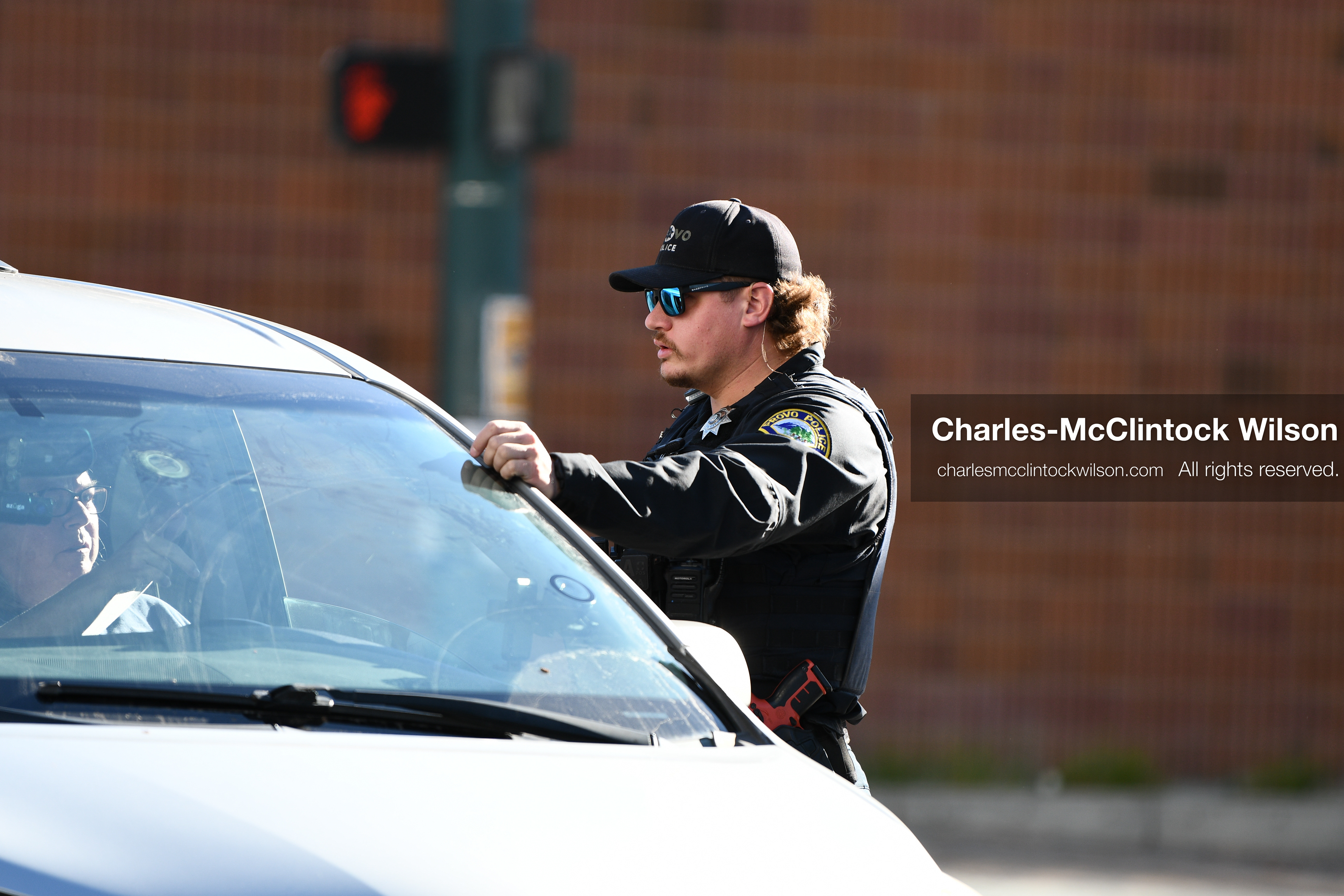 PROVO, UTAH, USA – DECEMBER 11, 2025: A Provo Police officer interacts with a vehicle near the Fourth District Court in Provo during the first in‑person court appearance of Tyler Robinson in the Charlie Kirk murder case. (Credit Image: © Charles‑McClintock Wilson/ZUMA Press Wire)
