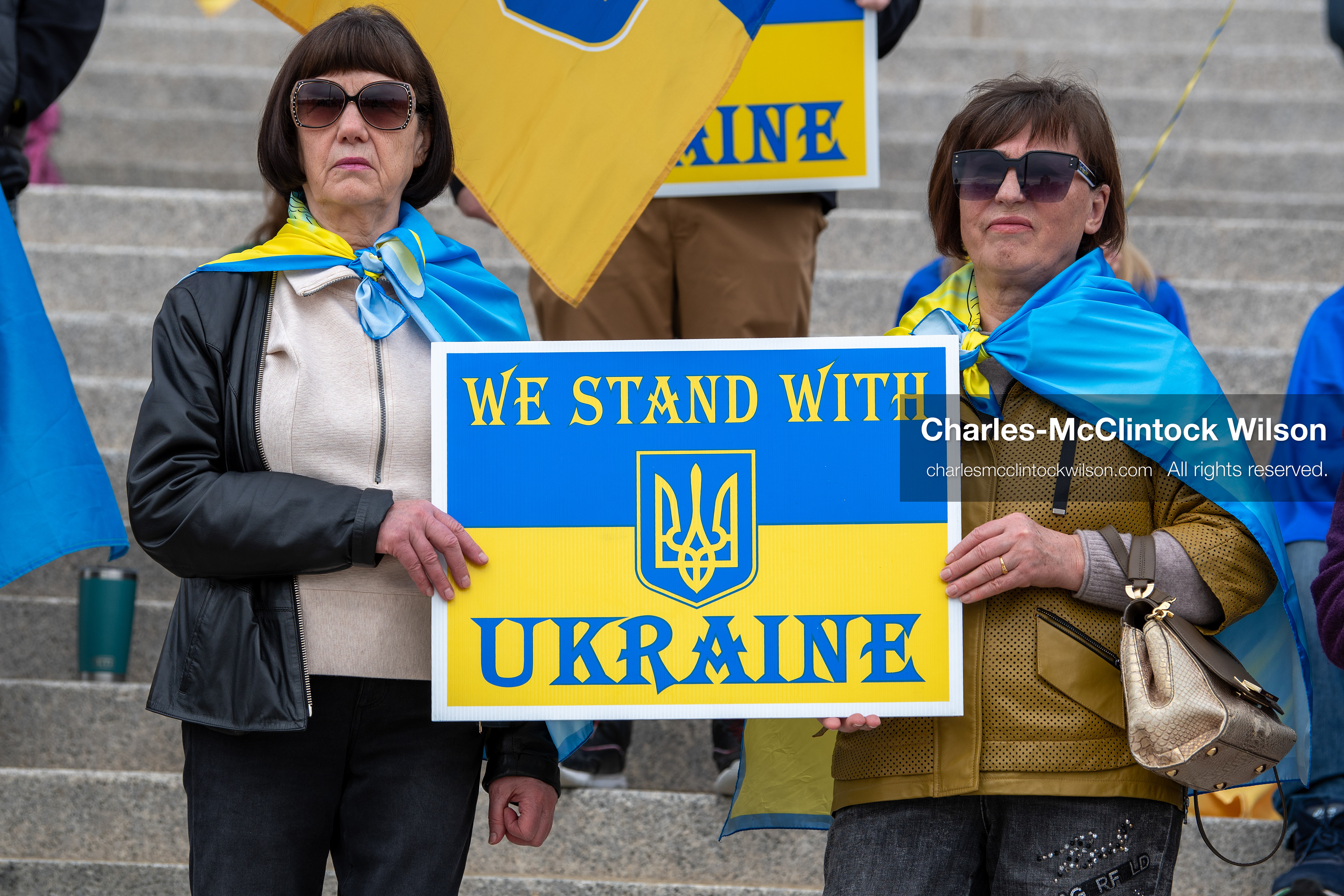  February 28, 2026, Salt Lake City, Utah, USA: Demonstrators hold signs reading We Stand With Ukraine while wrapped in the Ukrainian flag during the Stand With Ukraine rally at the Utah State Capitol. The gathering marked the four year anniversary of the full scale Russian invasion of Ukraine and brought community members together in support of Ukrainians and local humanitarian efforts. (Credit Image: © Charles McClintock Wilson/ZUMA Press Wire)