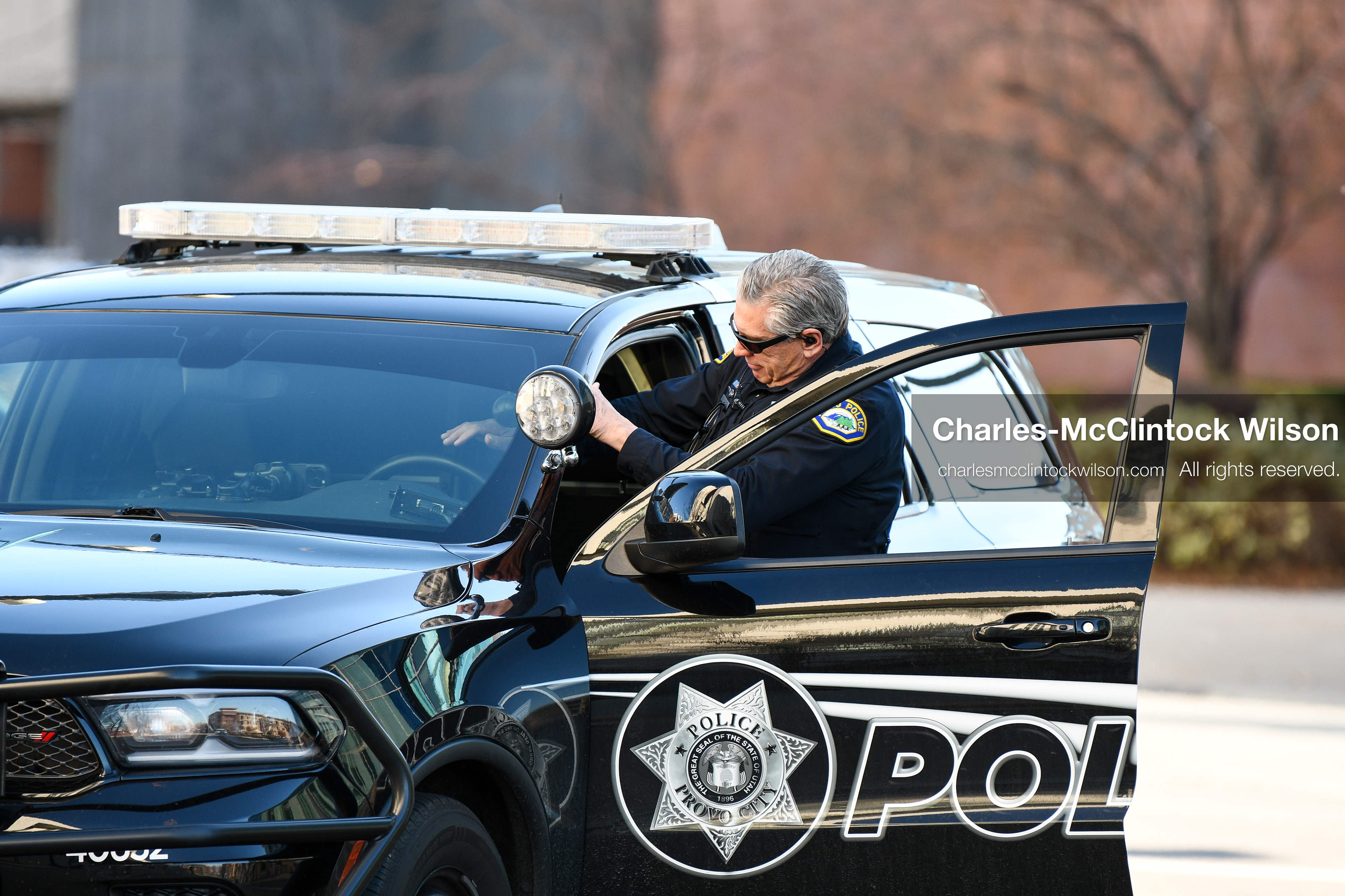 PROVO, UTAH, USA – DECEMBER 11, 2025: A Provo Police officer gets into a patrol vehicle near the Fourth District Court in Provo during the first in‑person court appearance of Tyler Robinson in the Charlie Kirk murder case. (Credit Image: © Charles‑McClintock Wilson/ZUMA Press Wire)