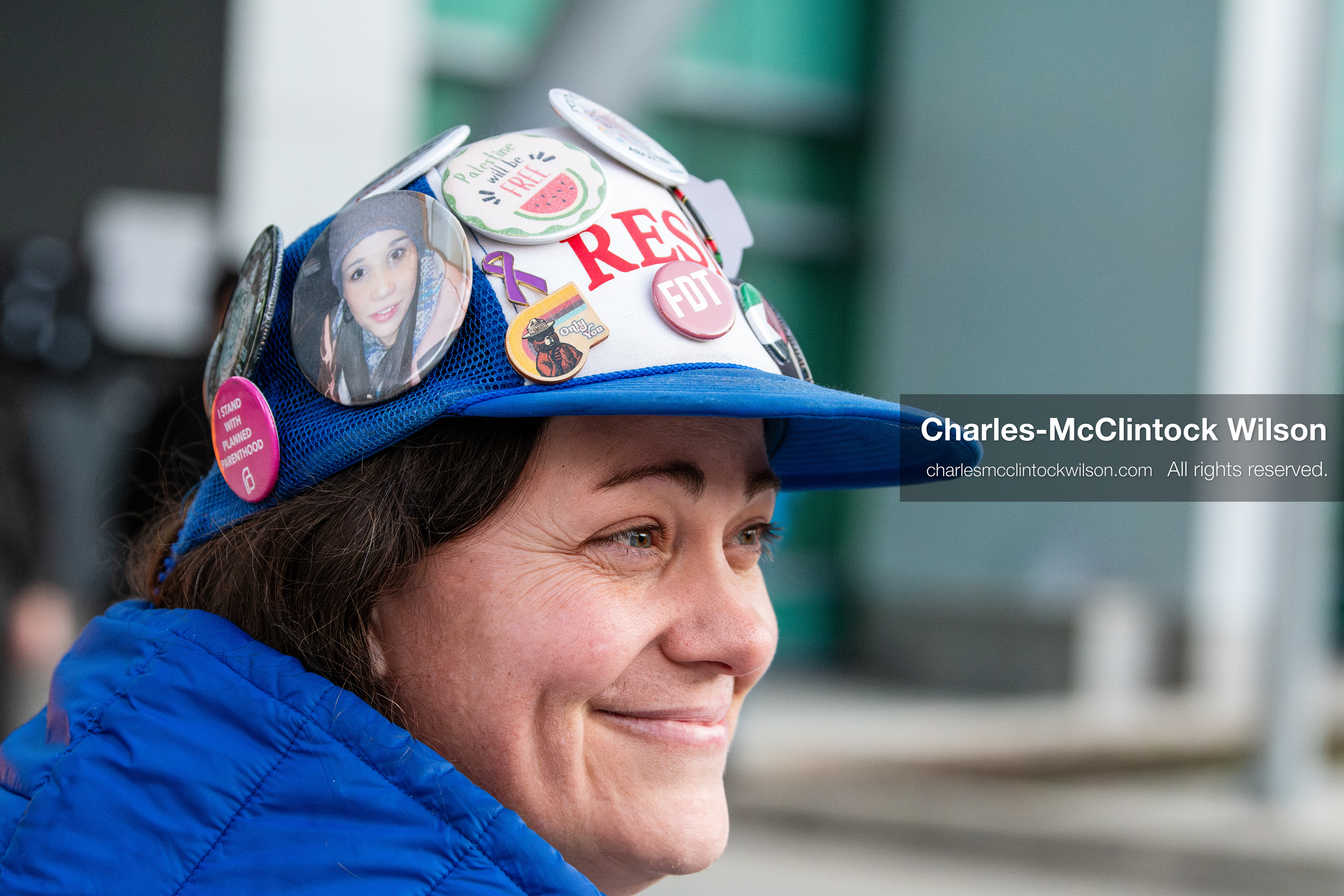 January 5, 2026, Salt Lake City, Utah, USA: A demonstrator wearing a blue cap adorned with colorful pins attends a protest outside the Wallace Federal Building in Salt Lake City, Utah. The rally, organized by Salt Lake Indivisible, called for congressional limits on presidential war powers following recent US military actions in Venezuela involving the government of Nicolas Maduro. Attendees signed petitions addressed to Utah US senators Mike Lee and John Curtis. (Credit Image: (c) Charles‑McClintock Wilson/ZUMA Press Wire)