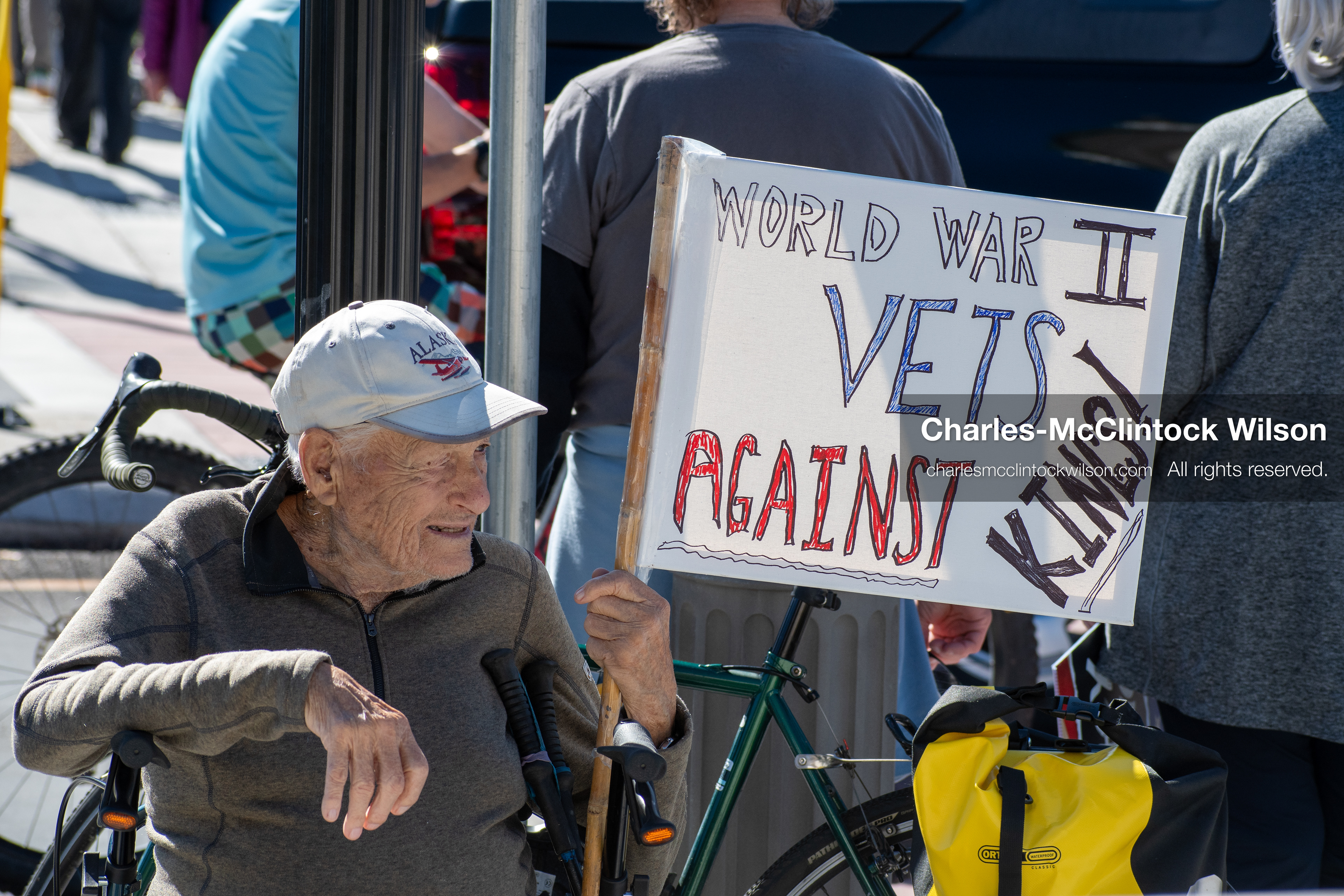 October 18, 2025, Salt Lake City, Utah, USA: A demonstrator raises a placard during a "No Kings" protest held at the Utah State Capitol. Other participants and signs are visible in the background during the public gathering.