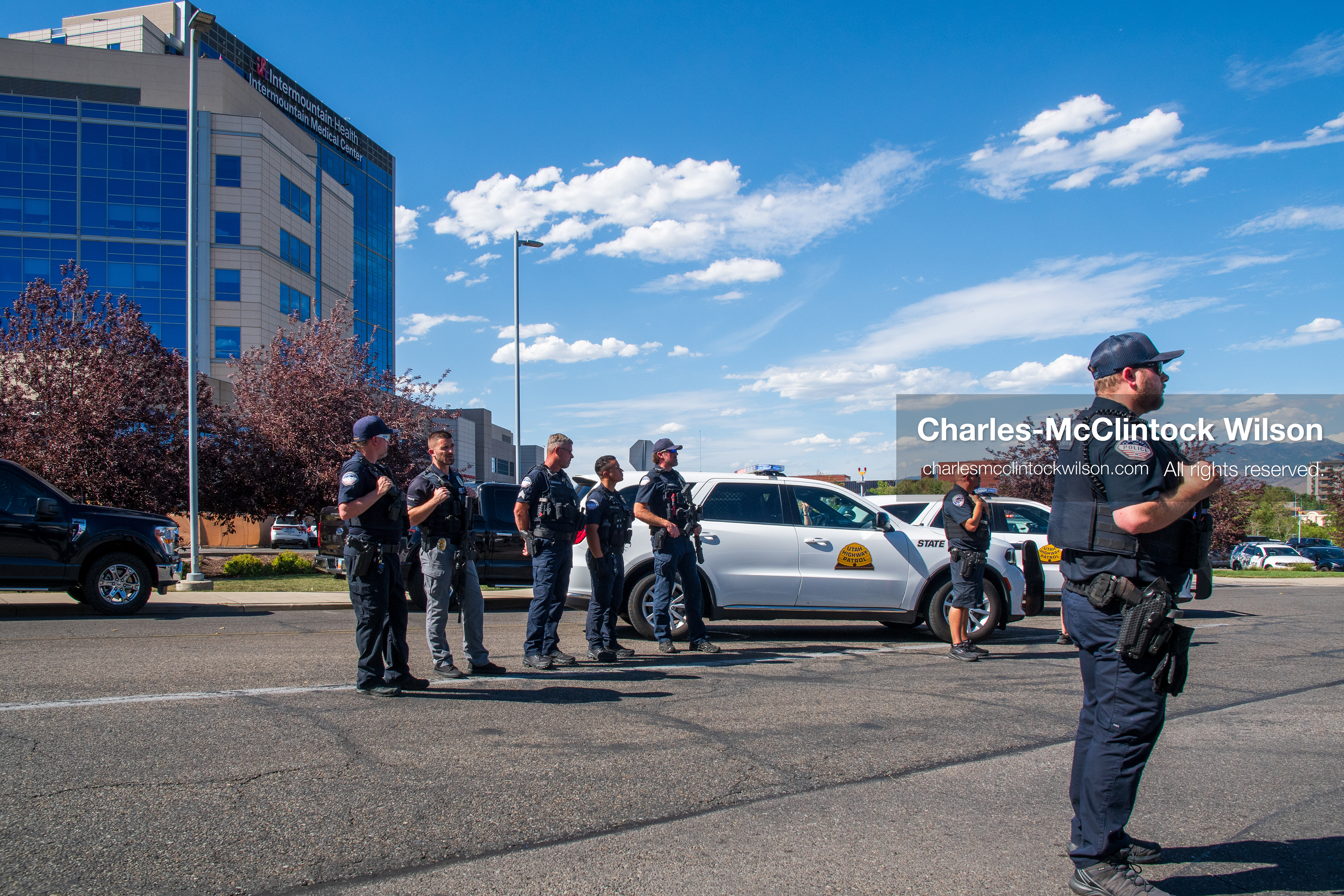 Law enforcement officers form a perimeter checkpoint line alongside parked police cruisers outside Intermountain Medical Center in Murray, Utah, on Monday, August 17, 2026. Multiple regional law enforcement agencies converged to heavily secure the hospital perimeter as a safety precaution after shooting victims arrived from a fatal shootout that erupted outside a funeral service in nearby Kearns earlier that day. (Photo by Charles-McClintock Wilson/Sipa USA)