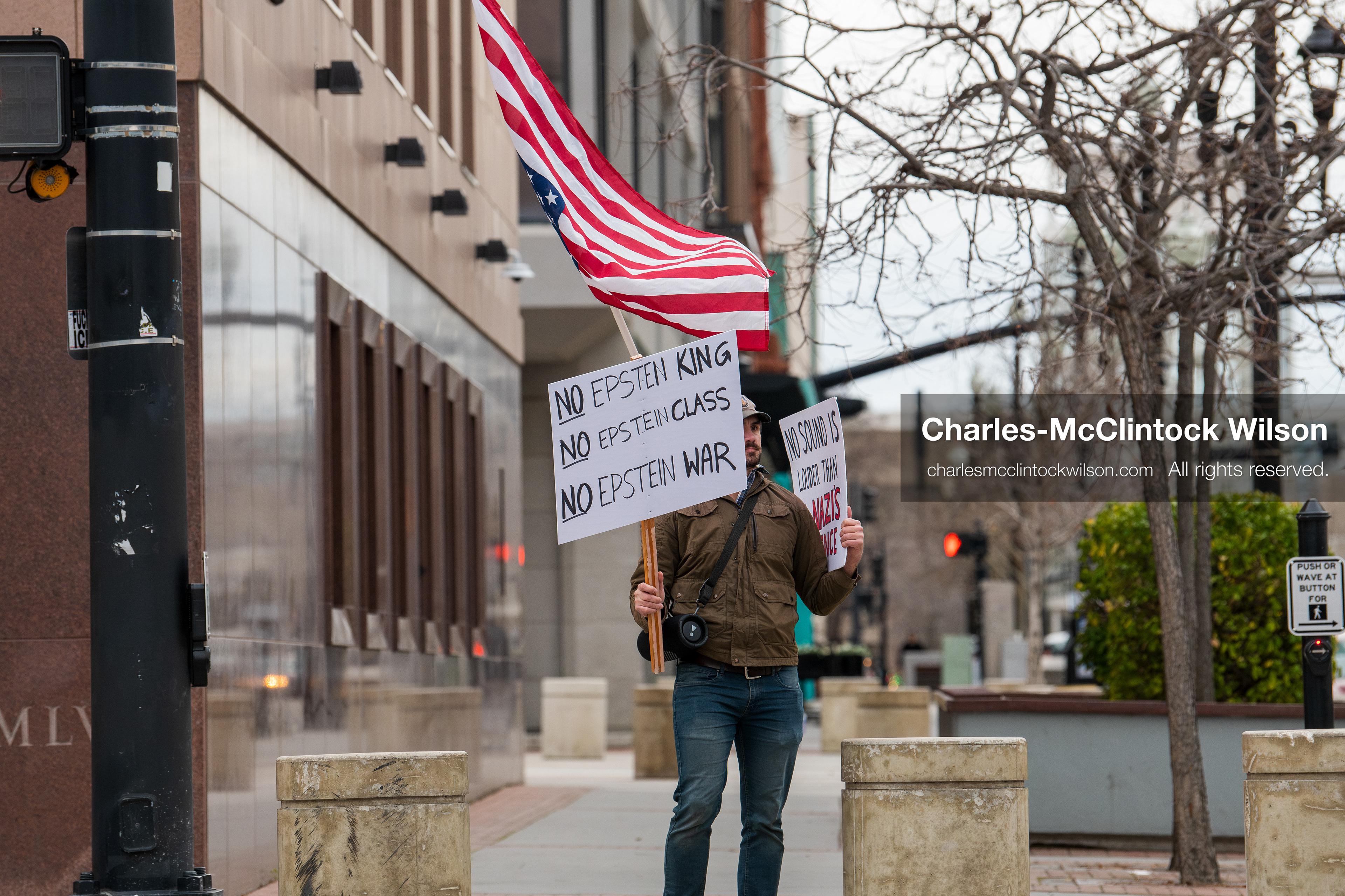 January 3, 2026, Salt Lake City, Utah, USA: A protester holds signs and an American flag during a demonstration against US action in Venezuela outside the Wallace Federal Building in Salt Lake City, Utah. The protest was part of a nationwide mobilization responding to recent military developments. (Credit Image: (c) Charles‑McClintock Wilson/ZUMA Press Wire)