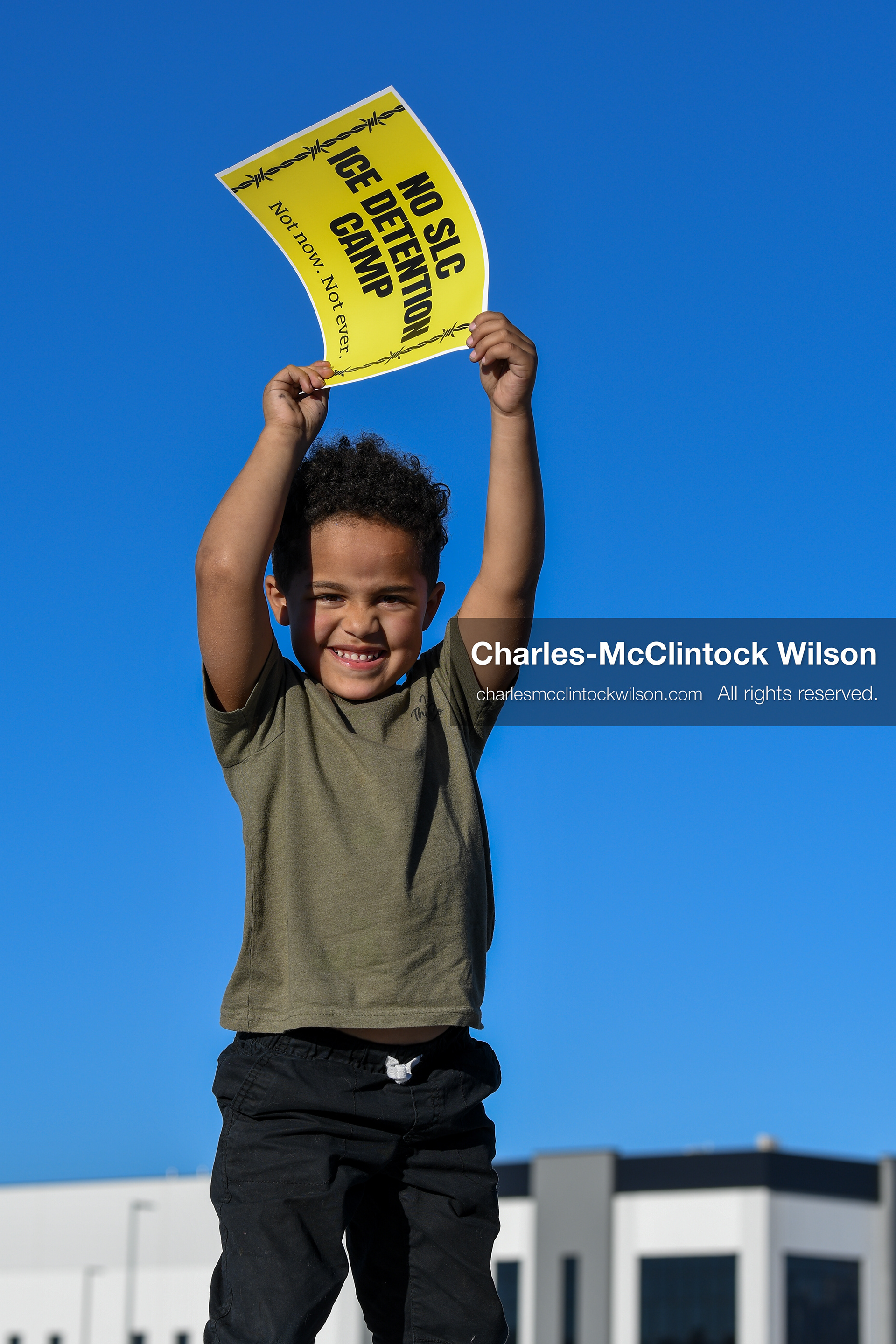 March 18, 2026, Salt Lake City, Utah, USA: A child holds a sign during a protest at the site of a proposed ICE detention facility on the west side of Salt Lake City. Demonstrators gathered at the warehouse property after federal officials confirmed the location was being considered for future detention operations. (Credit Image: © Charles McClintock Wilson/ZUMA Press Wire)