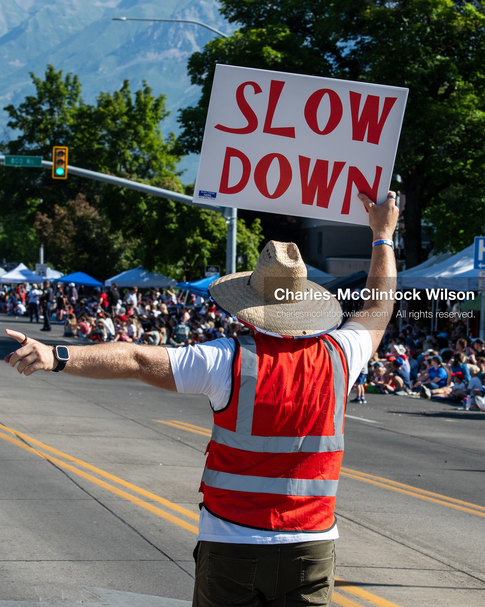 July 4, 2026, Provo, Utah, USA: An event marshal holding a ''Slow Down'' safety sign walks along the route ahead of the procession during America's Freedom Festival Grand Parade in Provo, Utah, Saturday, July 4, 2026. The annual event drew thousands of spectators to the downtown corridor. (Credit Image: © Charles-McClintock Wilson/ZUMA Press Wire)