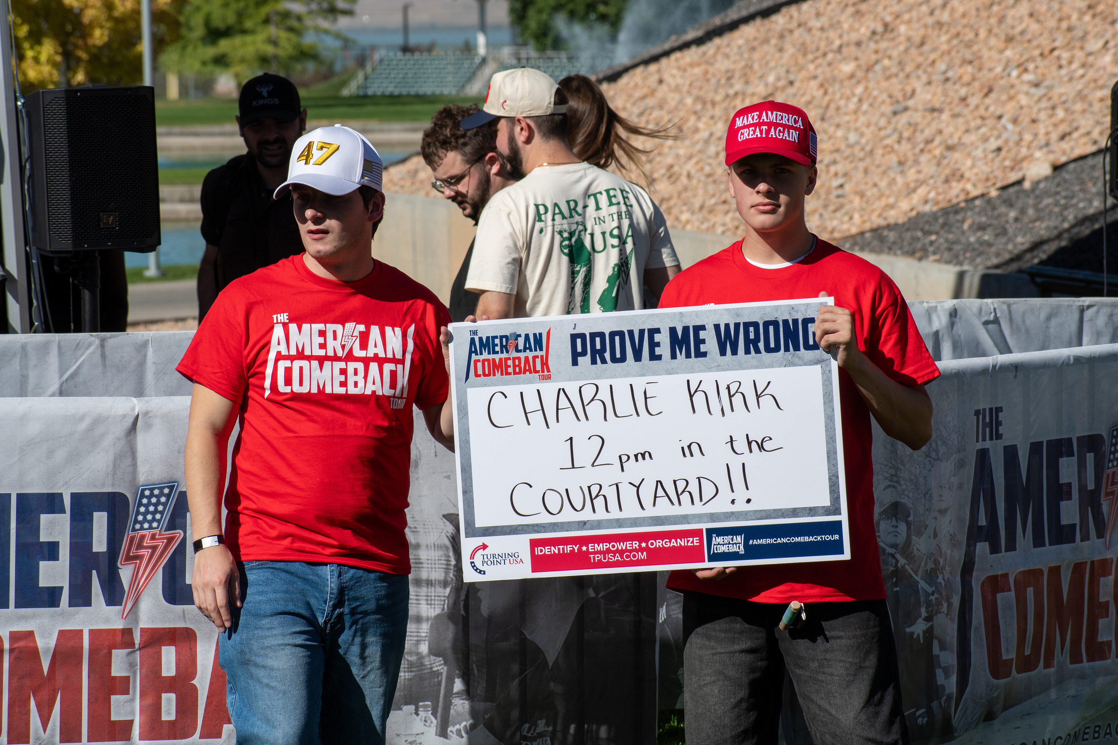 OREM, UTAH – SEPTEMBER 10, 2025: Attendees hold signage and wear matching red shirts at Utah Valley University during the opening stop of the American Comeback Tour. Positioned near the courtyard, the group reflects a moment of coordinated presence and public invitation. The image captures the visual messaging and communal energy that shaped the event’s atmosphere. © Charles-McClintock Wilson / ZUMA Press
