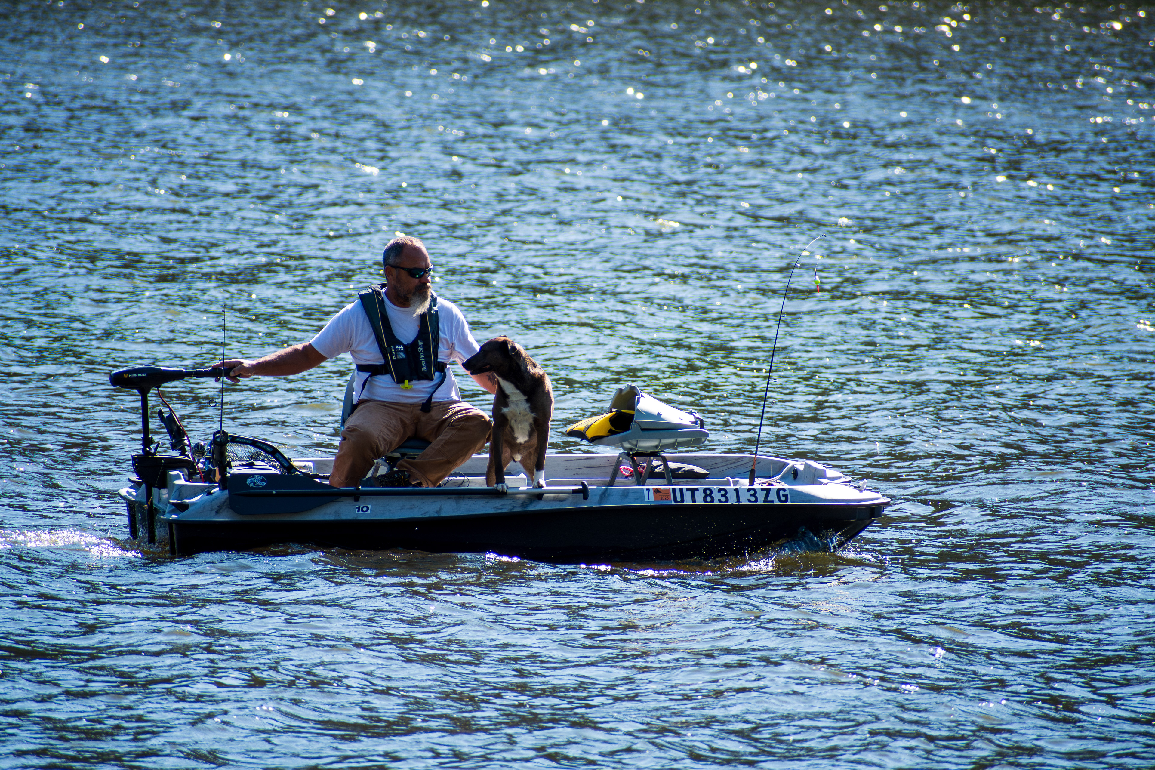 Summit County, Utah – July 20, 2025: A man and his dog ride together on a small boat at Smith and Morehouse Reservoir.