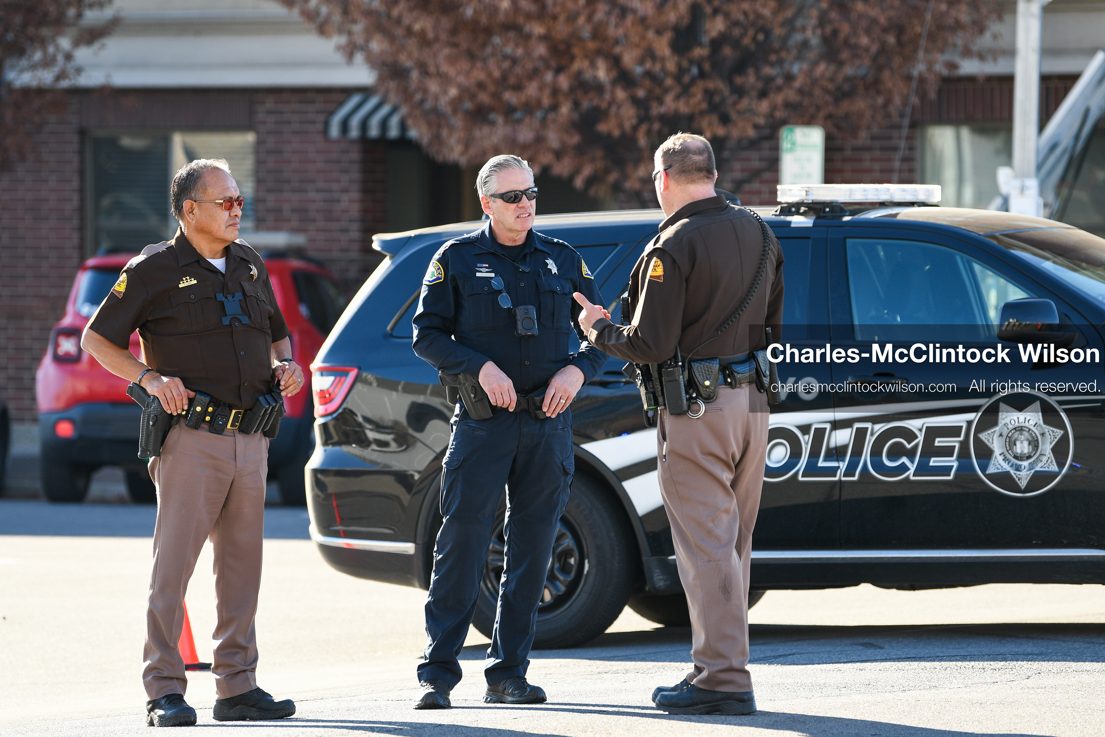 PROVO, UTAH, USA – DECEMBER 11, 2025: Two Utah Highway Patrol officers and a Provo Police officer converse outside the Fourth District Court in Provo during the first in‑person court appearance of Tyler Robinson in the Charlie Kirk murder case. (Credit Image: © Charles‑McClintock Wilson/ZUMA Press Wire)