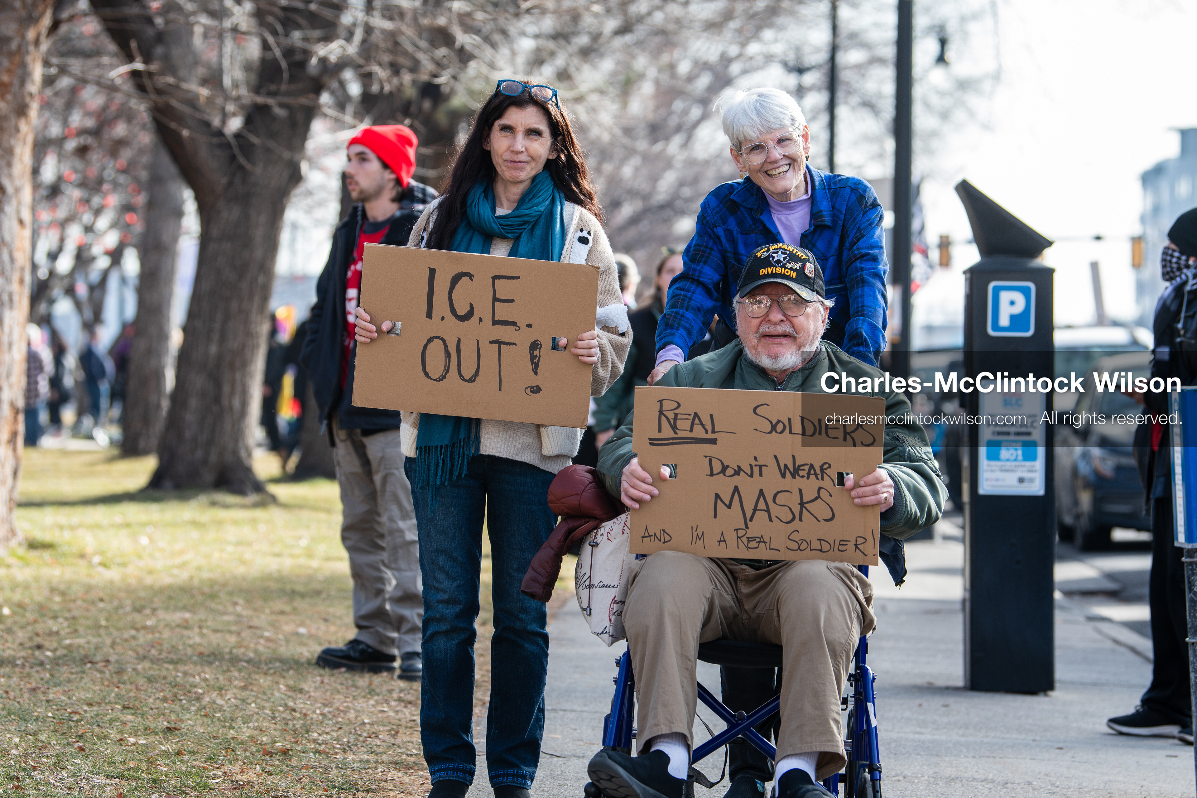 January 30, 2026, Salt Lake City, Utah, USA: Demonstrators, including a seated veteran, hold signs on the sidewalk during an anti‑ICE protest in Salt Lake City, part of a nationwide response to immigration enforcement policies. (Credit Image: © Charles‑McClintock Wilson/ZUMA Press Wire)