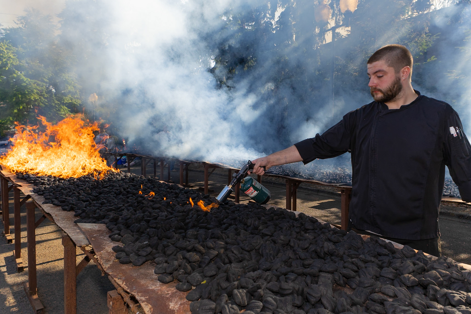 Daniel Pedersen, lead cook at Three Sisters,  prepares coals for the 2025 Lobster Feed in Lake Oswego, Oregon on June 14, 2025. The Lobster Feed raises millions of dollars for the Lakewood Center for the Arts.