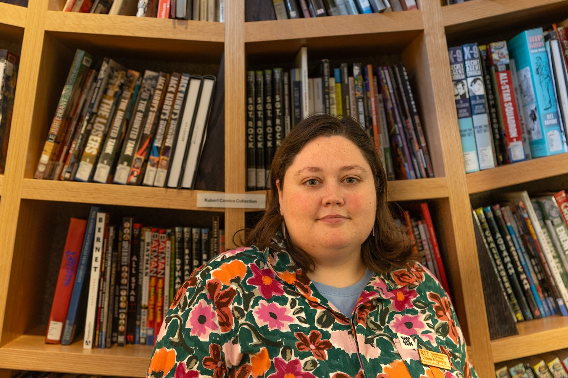 Claire Payne, RIT CAD Librarian, stands in front of the comic book shelf in the Wallace Library at RIT in Rochester, New York on Oct. 18, 2024.