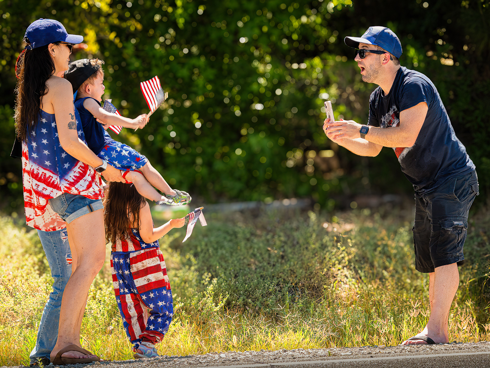 Family photo being taken on the 4th of July and the after is trying to get his young son to smile.. On the Santa Rosa Plateau in California.