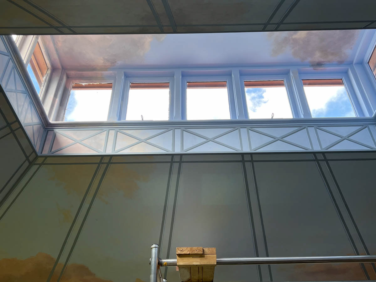The architecture of the room lent itself to the painting of a greenhouse structure or aviary in trompe l’oeil.