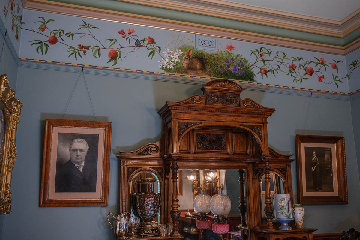 The paintings are installed and glued to the walls. The plant frieze is underlined by a decorative spiral border. All the work is hand painted.
