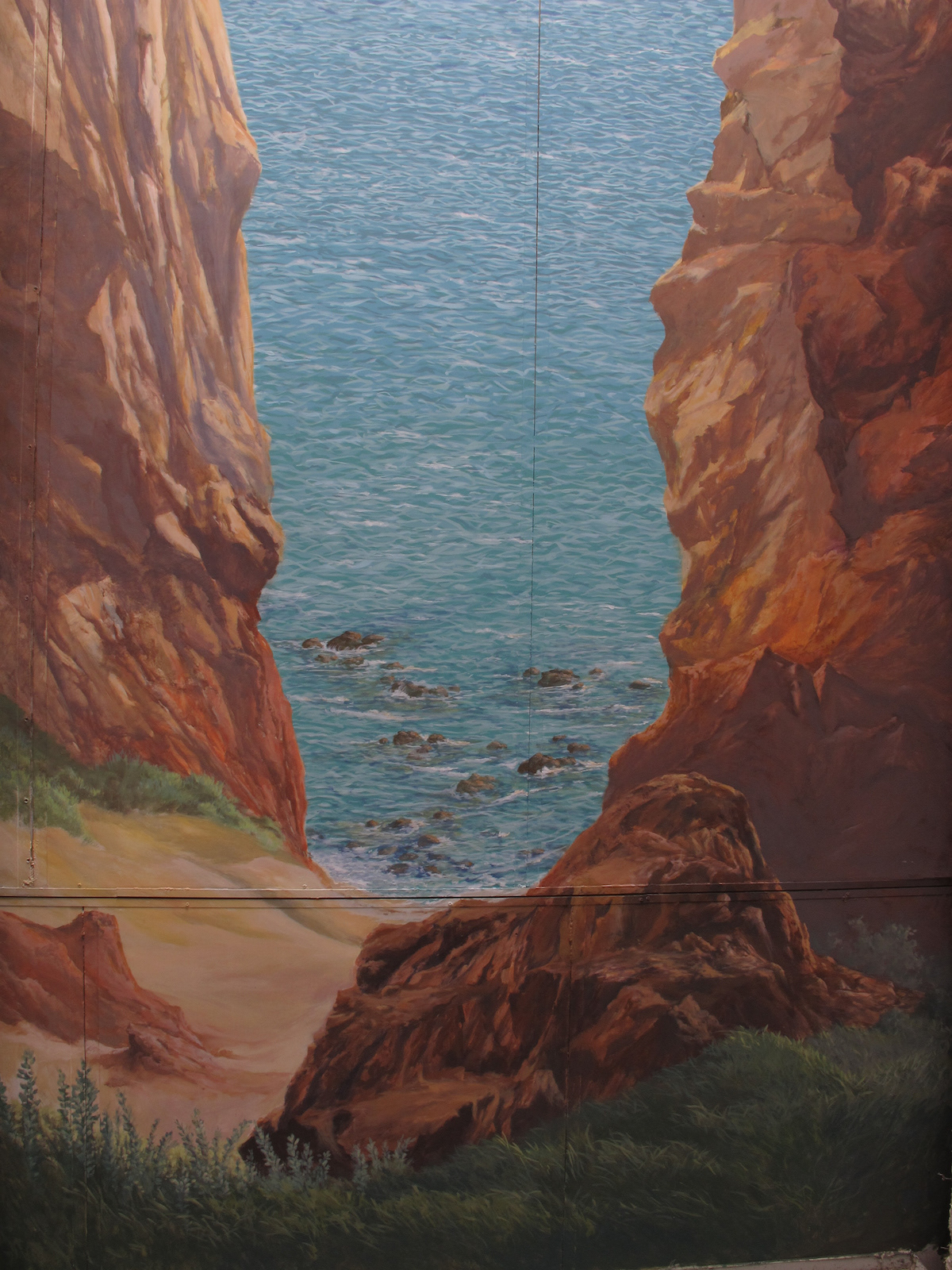 Rocks overhang the sea