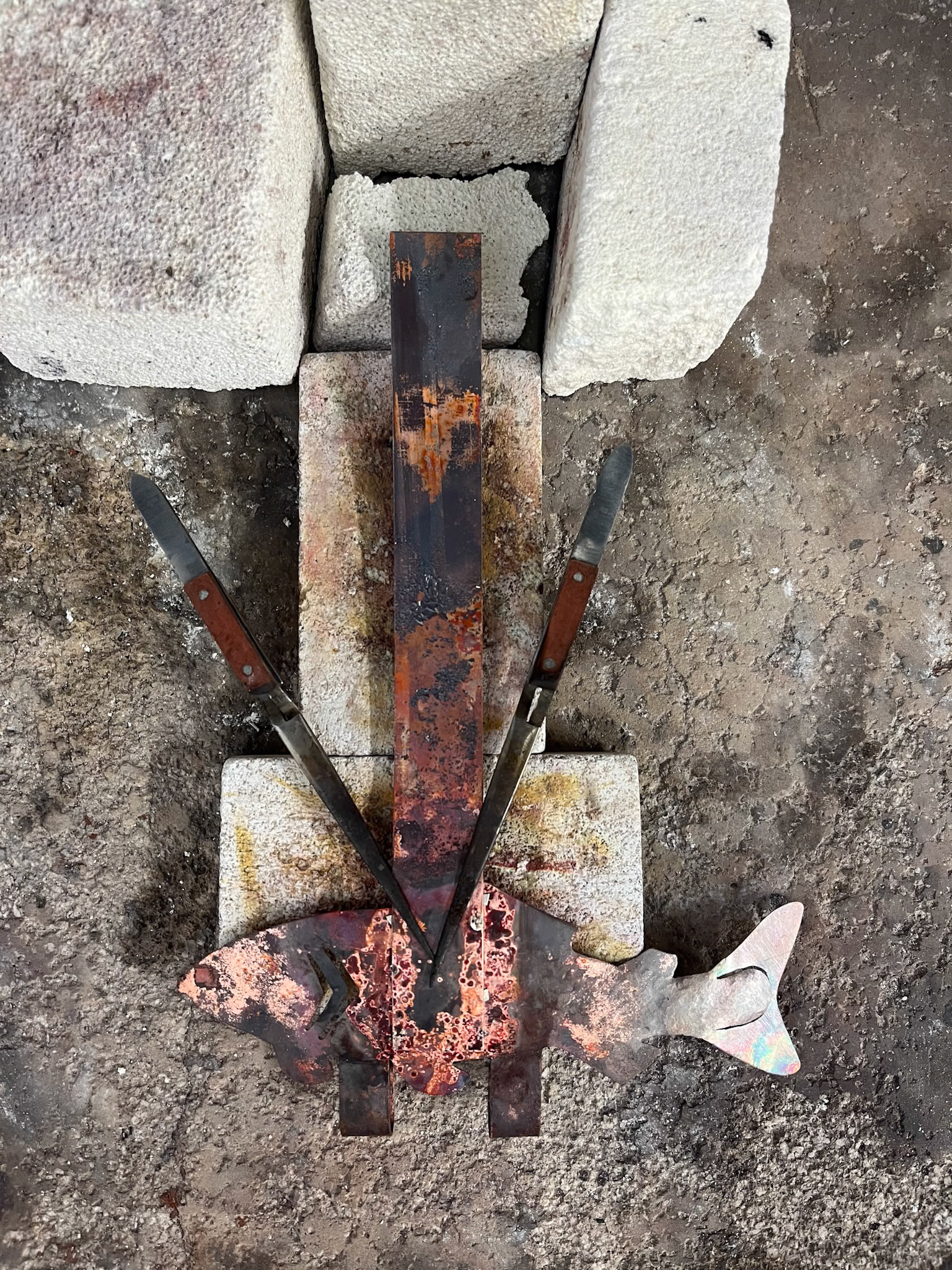 Reverse action tweezers were used to hold the fish and the over door piece/hooks together while silver soldering.  