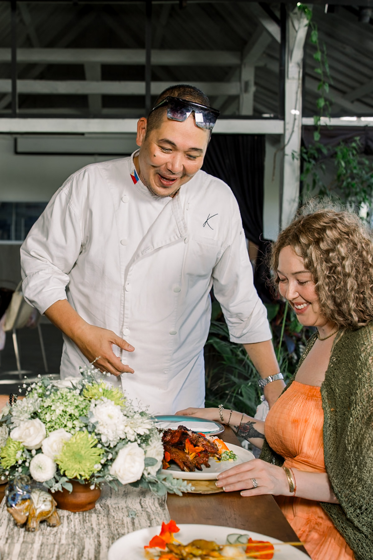 Professional photo of Kilig's chef, explaining the dish to a customer.