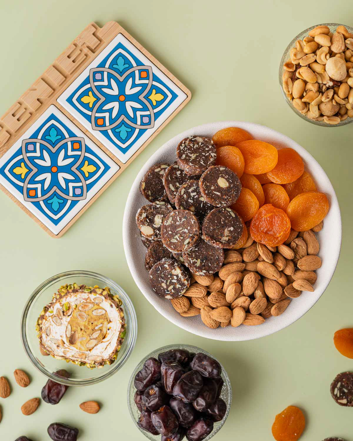 Dadelkoekjes, dadles, abrikozen, noten, en mozaiekplankje productfotografie.