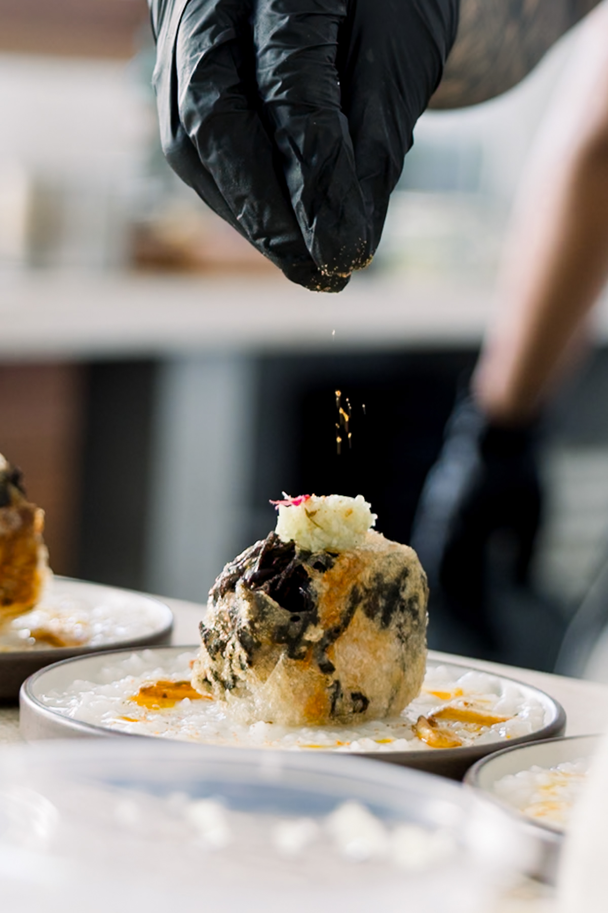 Sprinkling chili powder on the dish, captured by Bali photographer.