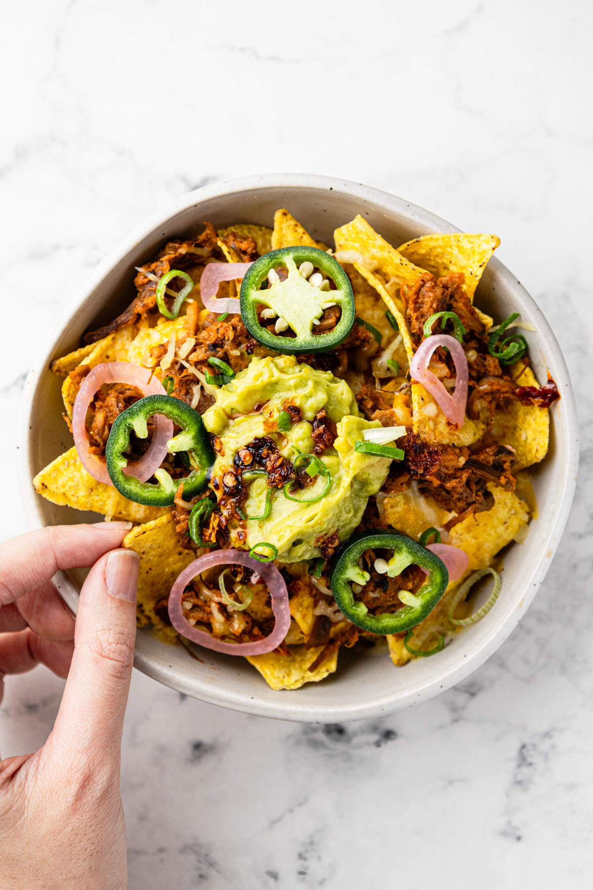 Nachos met guacamole en chili crisp, vastgelegd door een culinaire fotograaf.