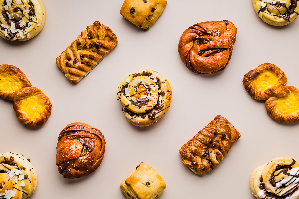 Zoete broodjes op een beige achtergrond, gefotografeerd door een Amsterdamse foodfotograaf.