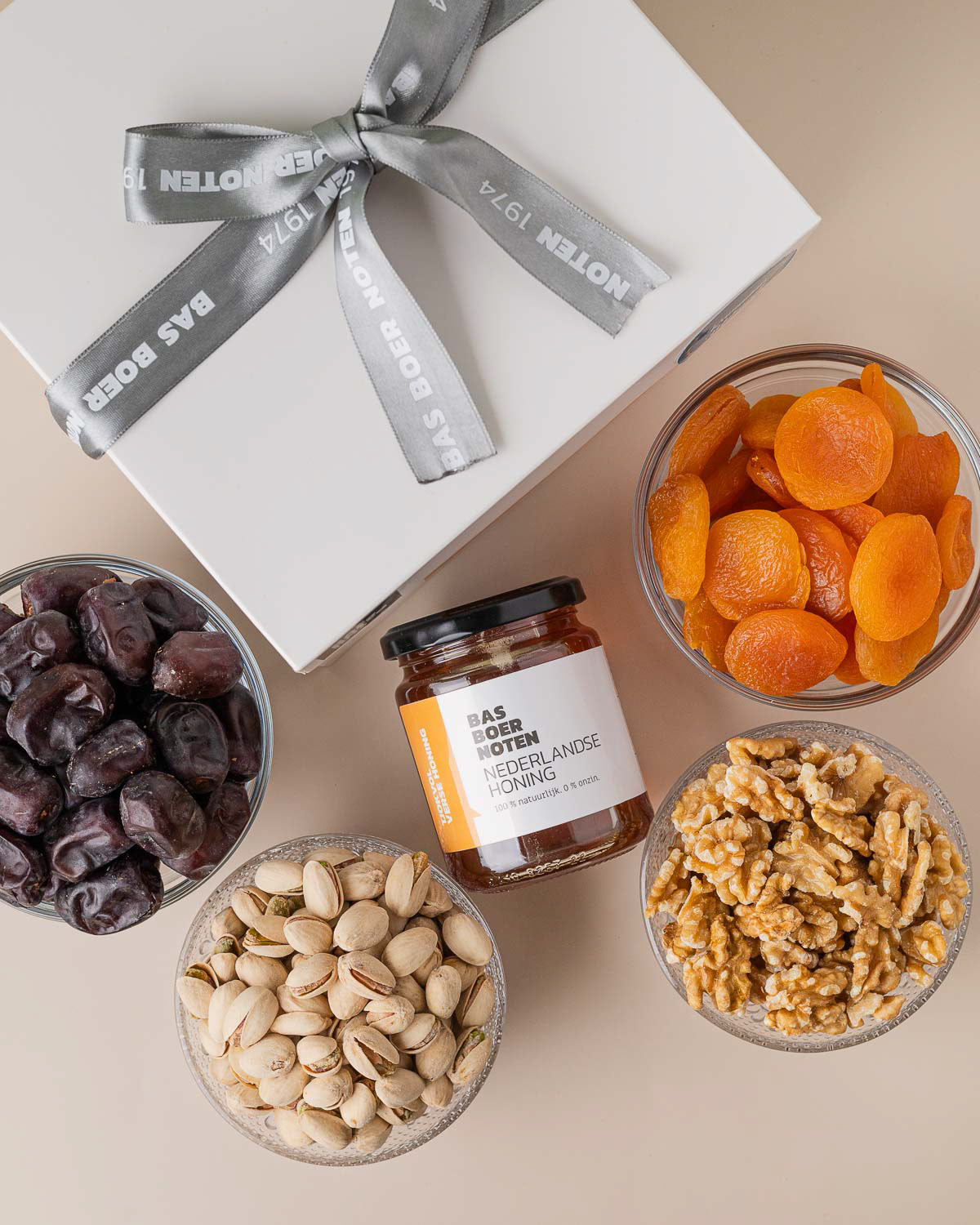 Nederlandse honing met glazen schaaltjes gevuld met gedroogd fruit en noten, gefotografeerd door een voedingsfotograaf in Amsterdam.