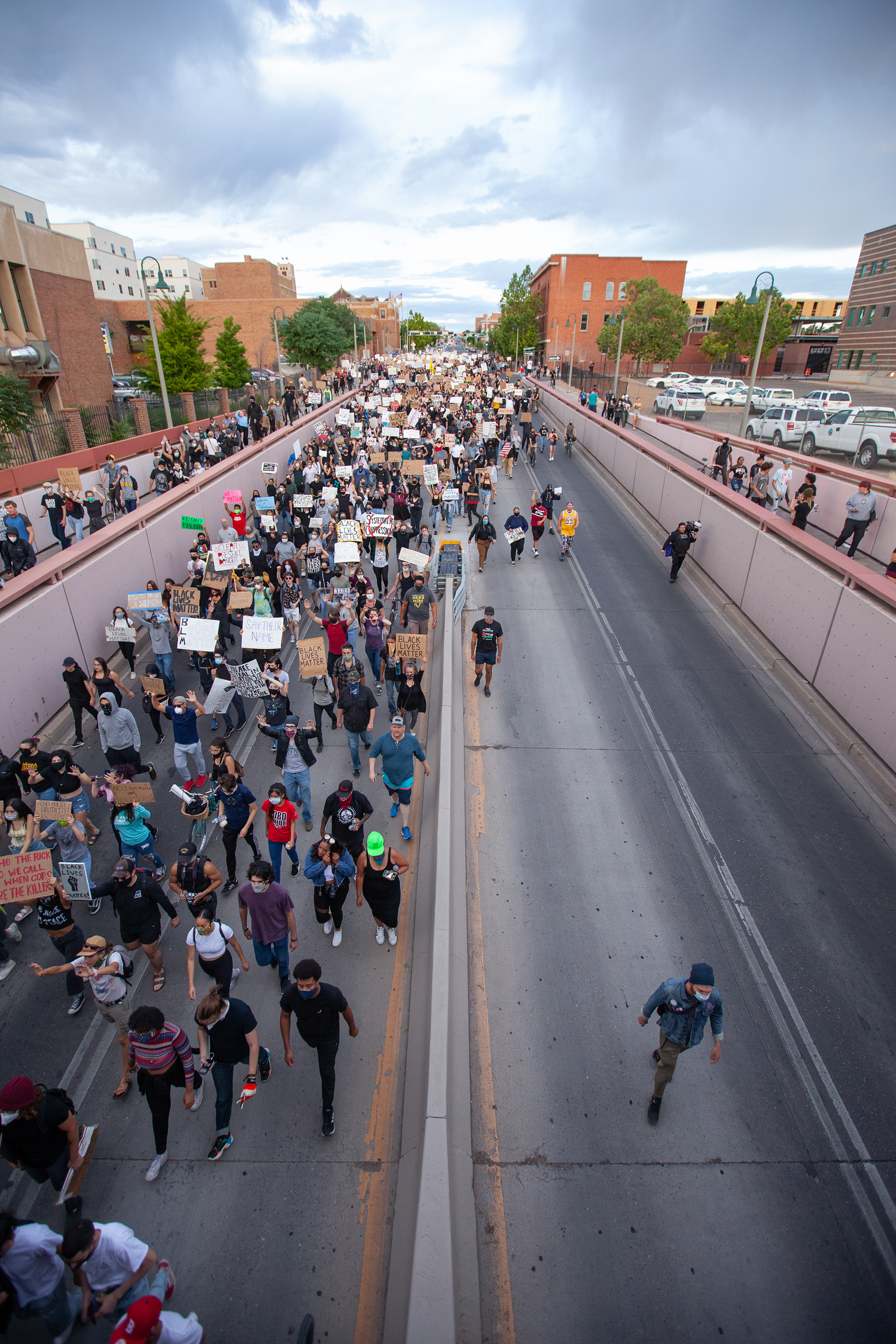 Aerial view of a protest march flooding the streets, as a crowd of demonstrators carry signs demanding justice for George Floyd, photographed in early June 2020.