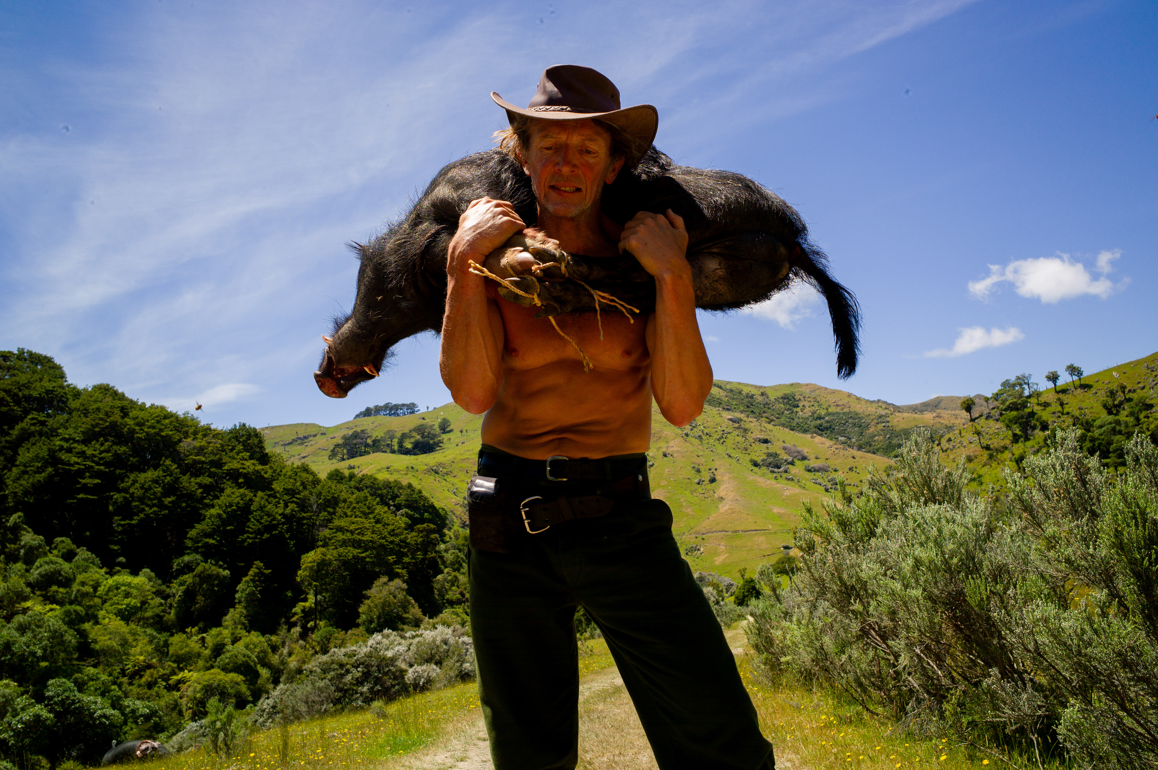 Steven Ciprian carrying a wild boar on his back. Depicting a hunt common in the region.