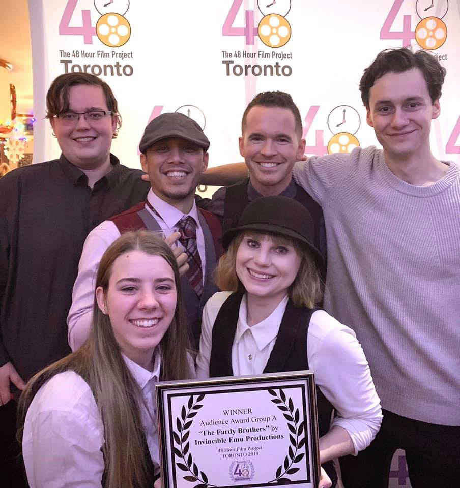 Mandi holding an award with "The Fardy Brothers" cast and crew.