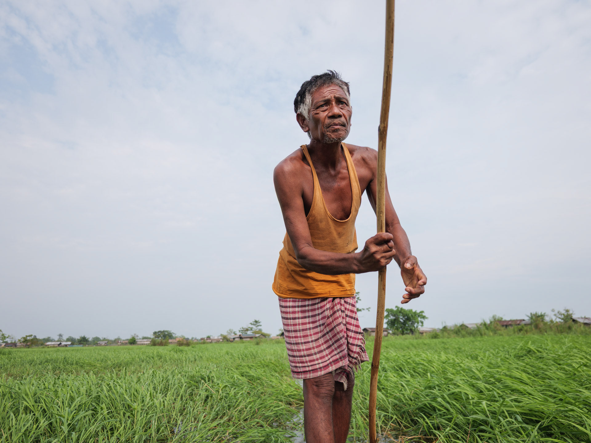 A man pushing his boat through the floodlands on his home island on the Brahmaputra river
