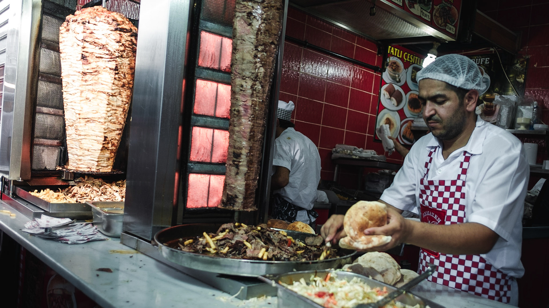 A man prepares a kebap on a roll. Sadly, I could not find too many places with kebabs on a flatbed and with a choice of hot sauses that are very popular in other parts of Europe.