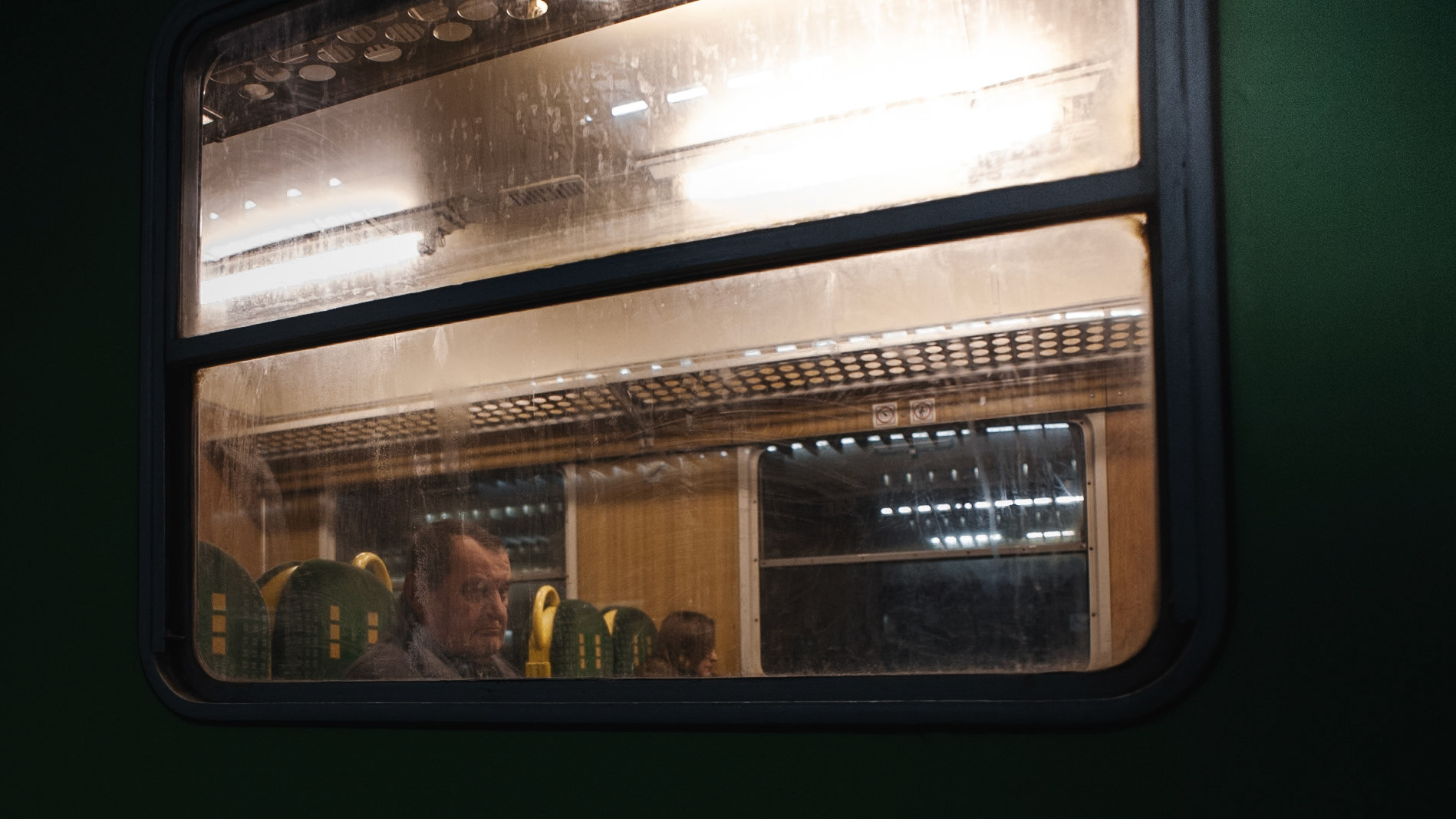 A visibly tired passenger awaits train departure from the Warsaw's Central Station.