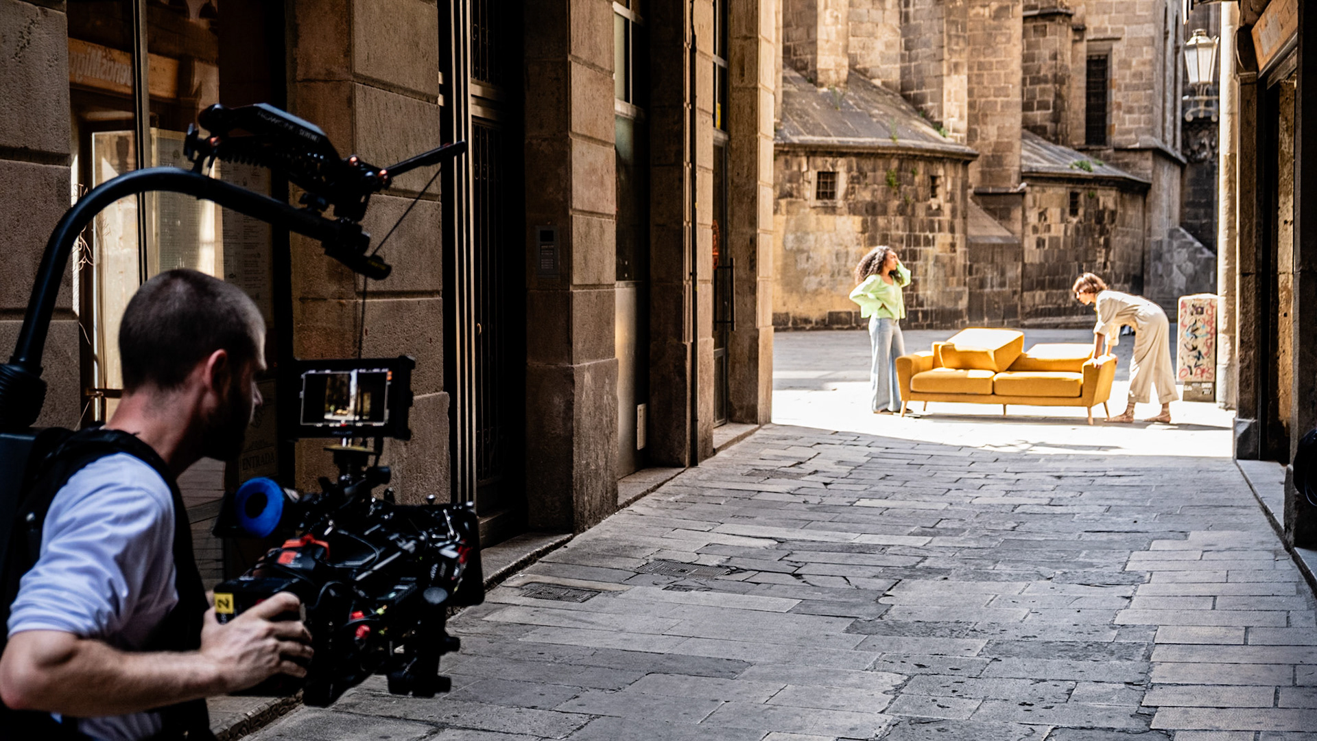 A film crew shoots an episode with a yellow sofa on the streets of historic Gothic Quarter in Barcelona