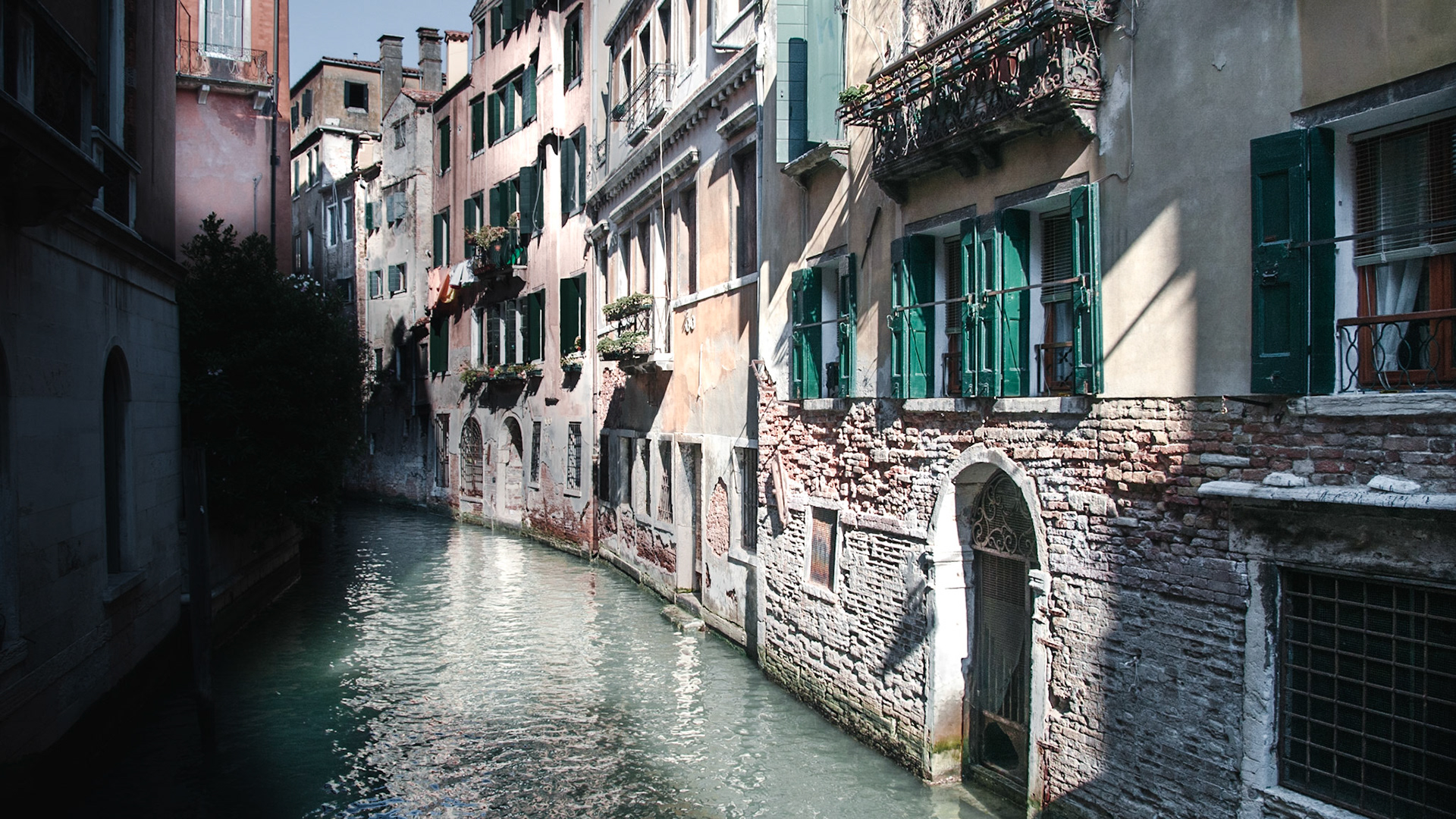 One of many canals in the city with weathered brick walls.